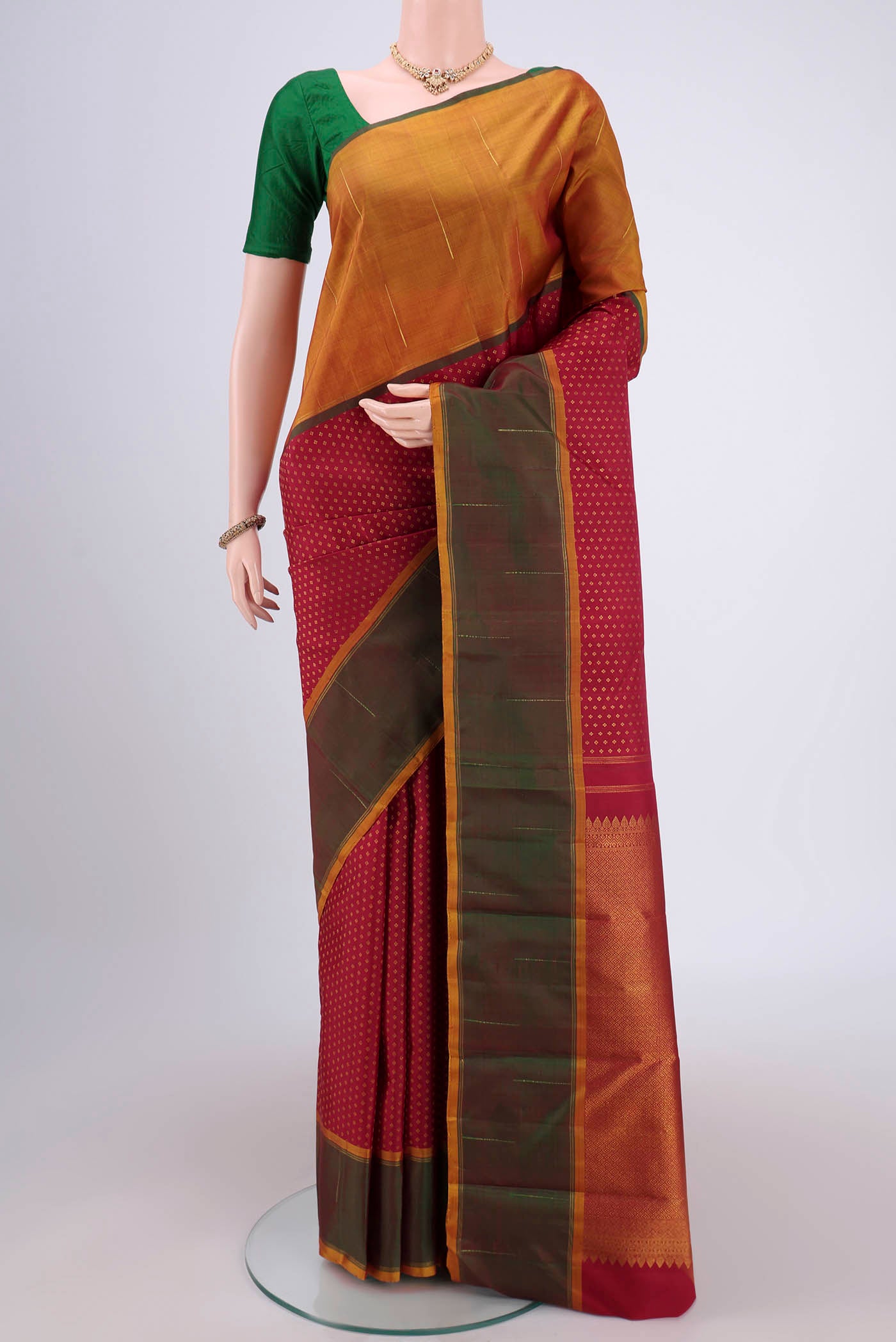 Maroon Dual Tone Kanjivaram Silk Saree with Zari Butta on the body and Ganga Jamuna Border.  displayed on a mannequin