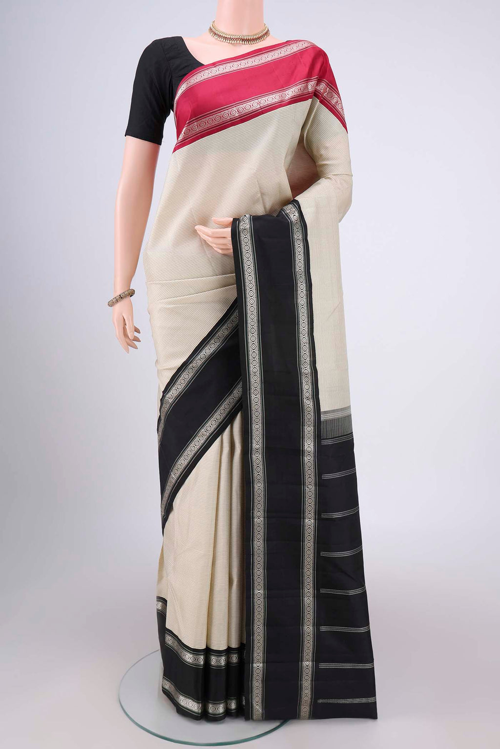 Off White Kanjivaram Silk Saree with Stripes on the body and Ganga Jamuna Border.  displayed on a mannequin