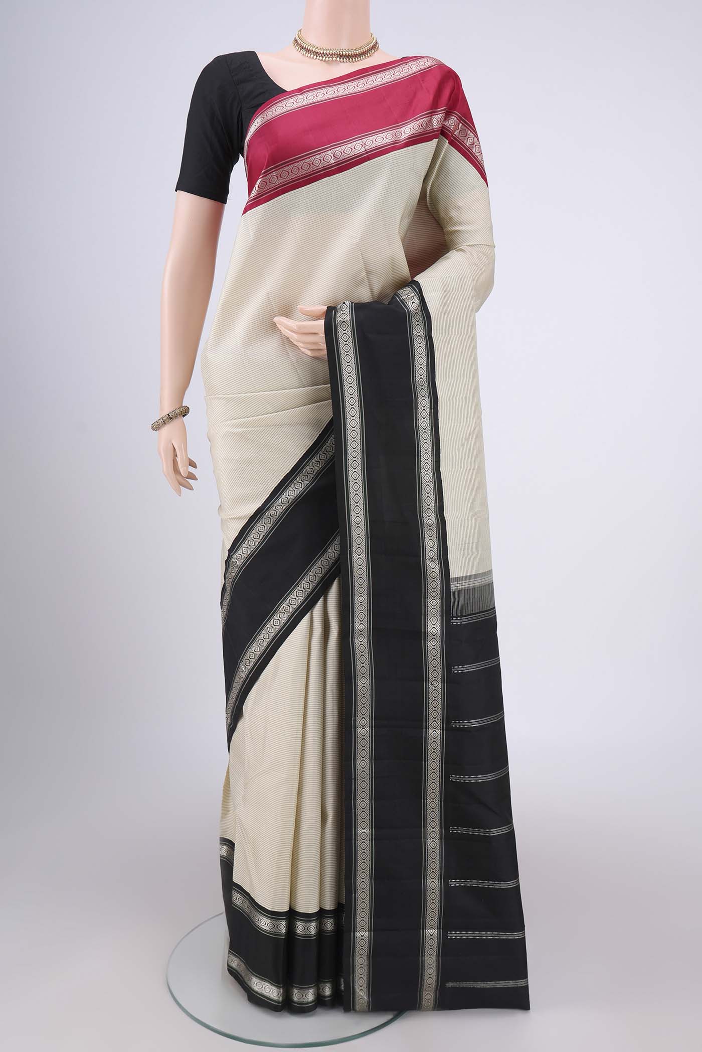 Off White Kanjivaram Silk Saree with Stripes on the body and Ganga Jamuna Border.  displayed on a mannequin