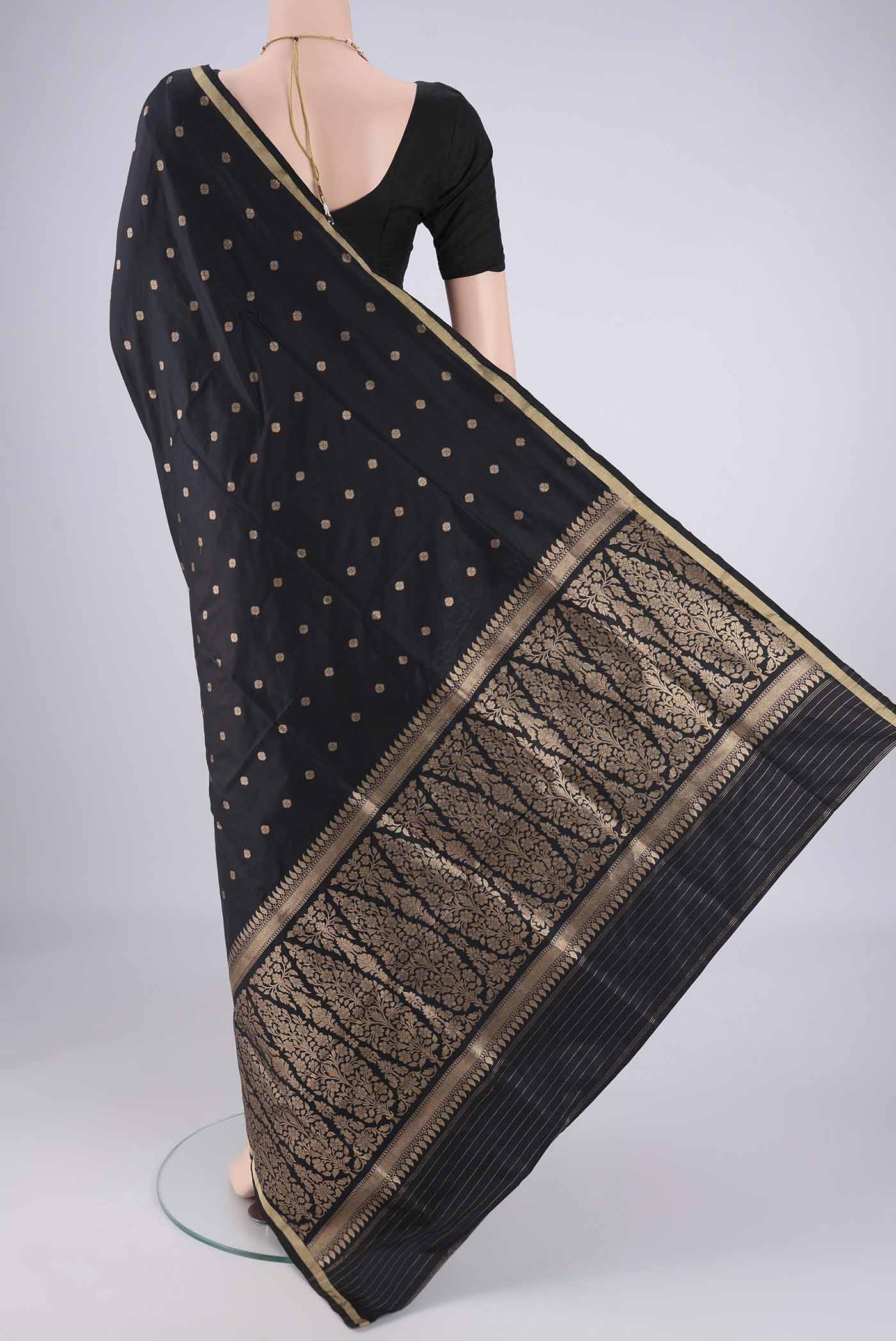 Flat view of Black Banarasi Silk Saree with Zari Butta on the body and Thin Zari Line. 