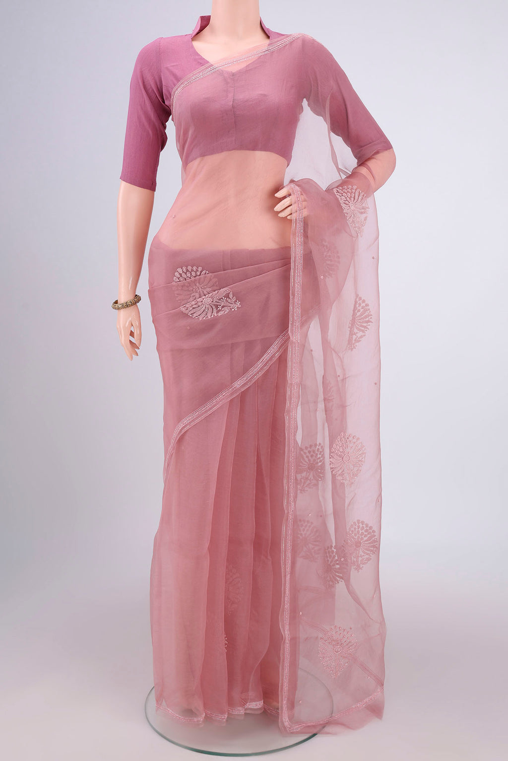 Rose Gold Organza Silk Saree with Embroidery on the body and Thin Zari Line.  displayed on a mannequin