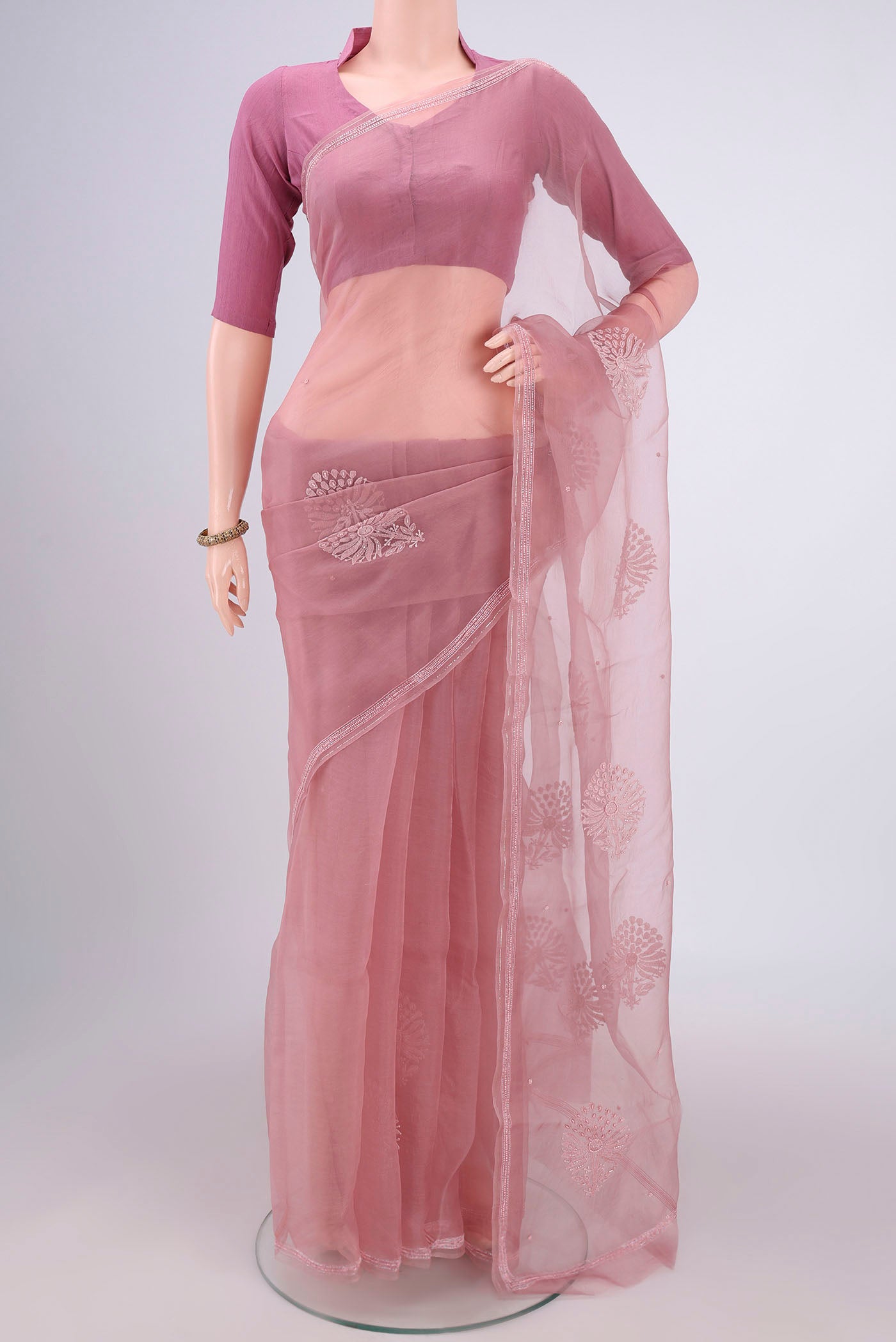 Rose Gold Organza Silk Saree with Embroidery on the body and Thin Zari Line.  displayed on a mannequin