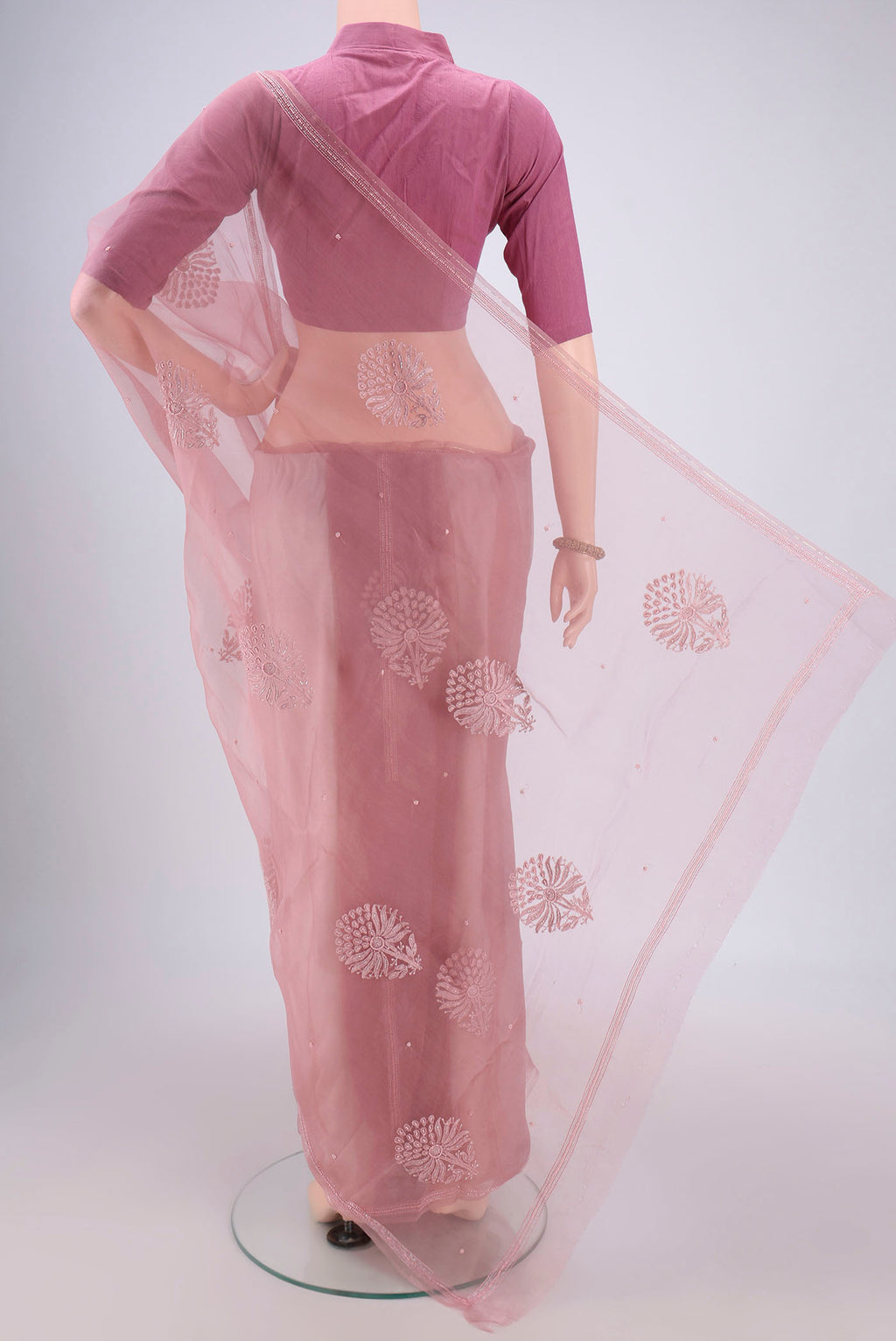 Flat view of Rose Gold Organza Silk Saree with Embroidery on the body and Thin Zari Line. 