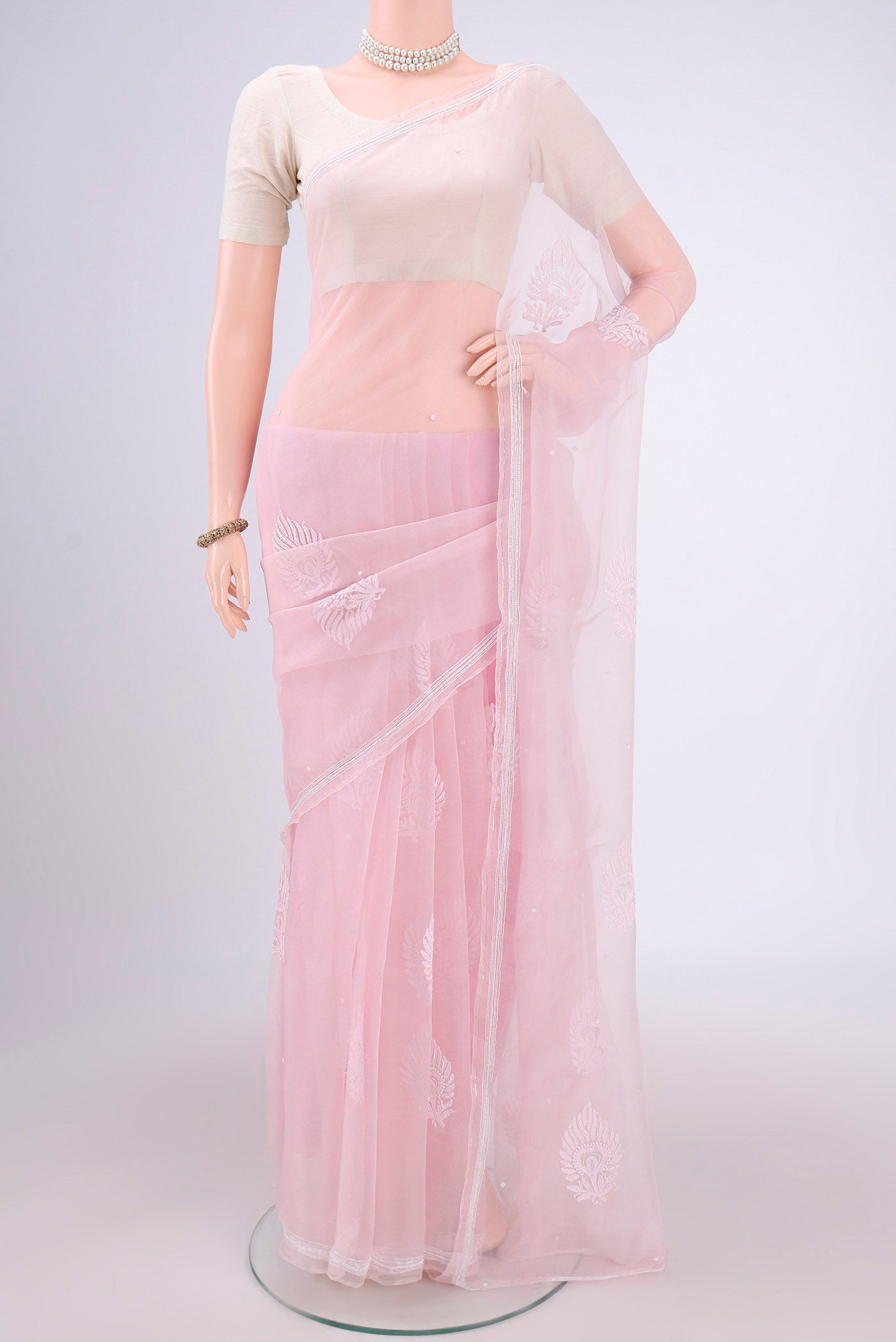 Rose pink Organza Silk Saree with Embroidery on the body and Thin Zari Line.  displayed on a mannequin