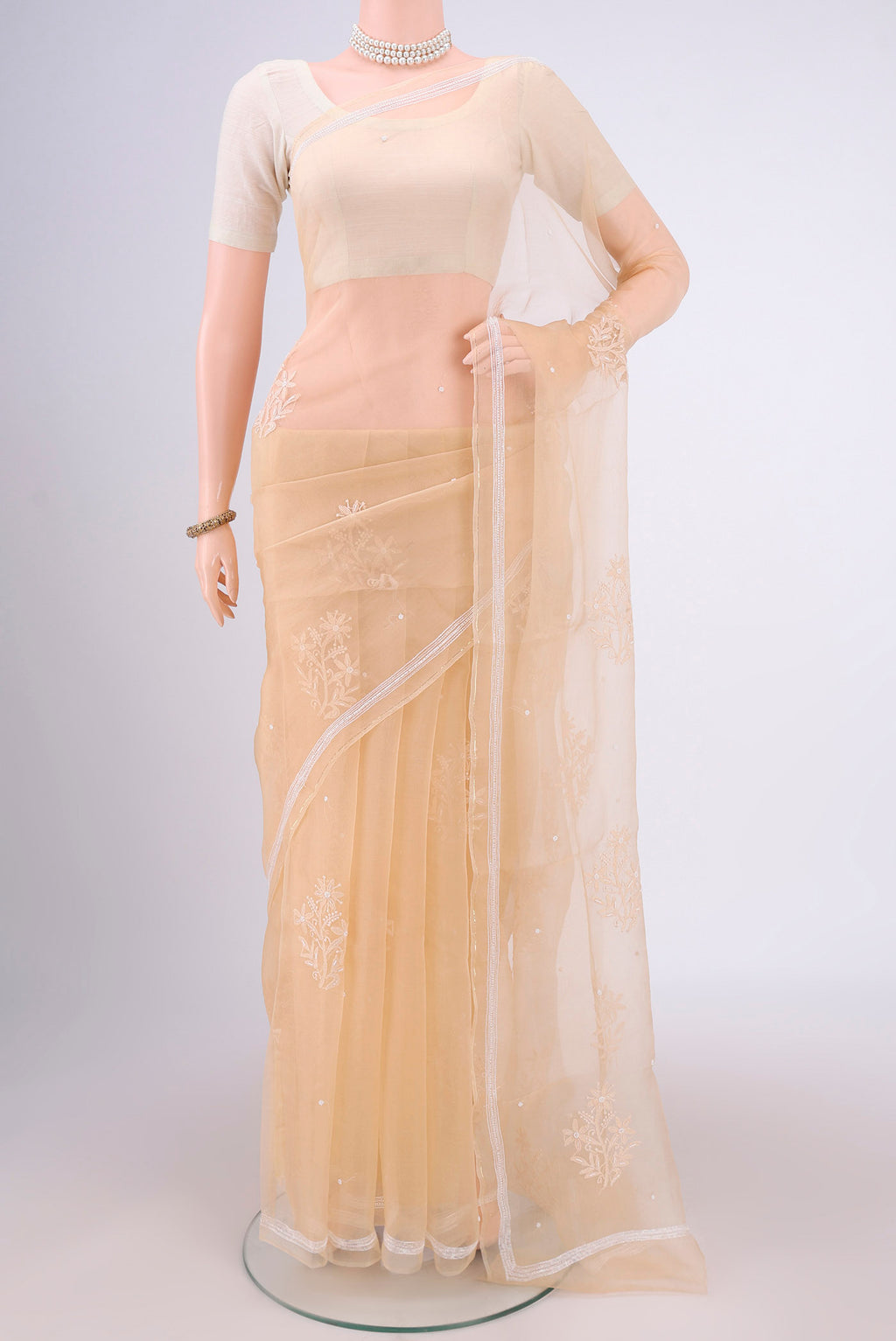 Beige Organza Silk Saree with Embroidery on the body and Thin Zari Line.  displayed on a mannequin