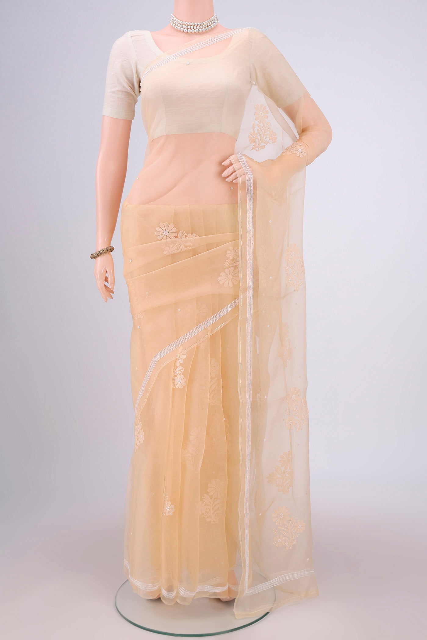 Sandal Organza Silk Saree with Embroidery on the body and Thin Zari Line.  displayed on a mannequin