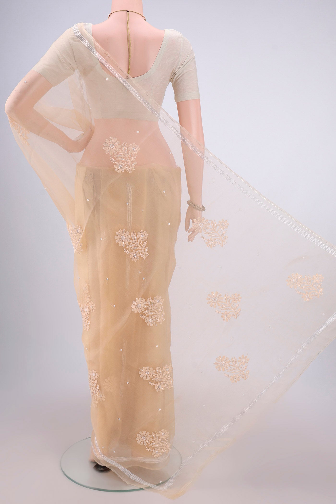 Flat view of Sandal Organza Silk Saree with Embroidery on the body and Thin Zari Line. 