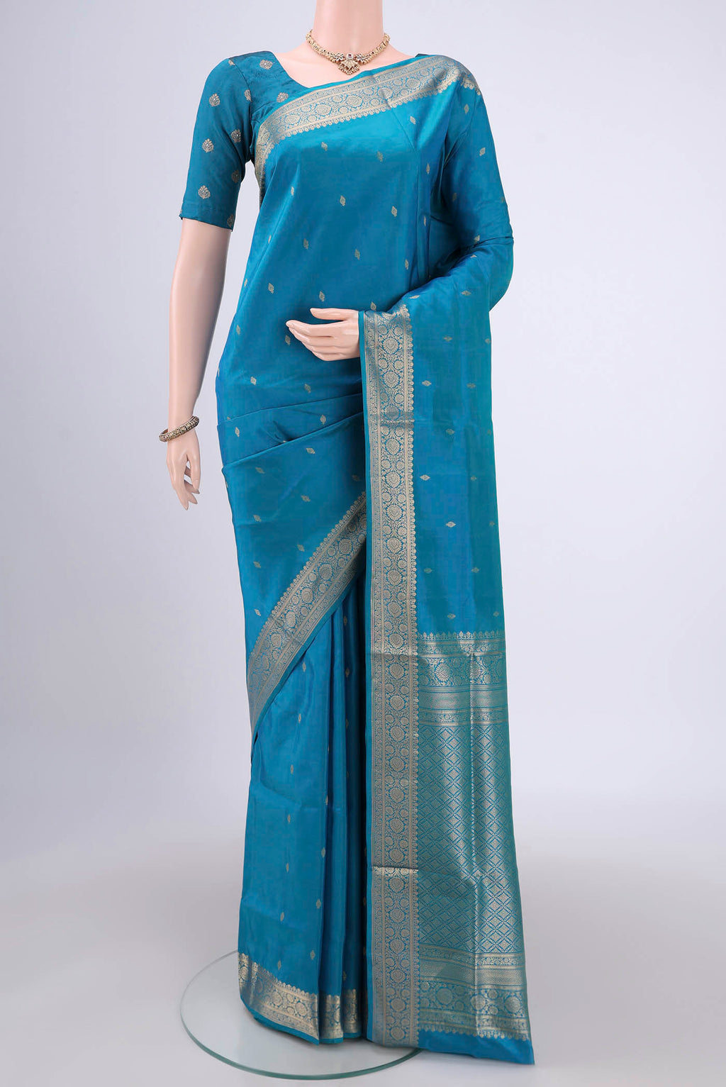 Turquoise Soft Silk Saree with Zari Butta on the body and Zari Border.  displayed on a mannequin
