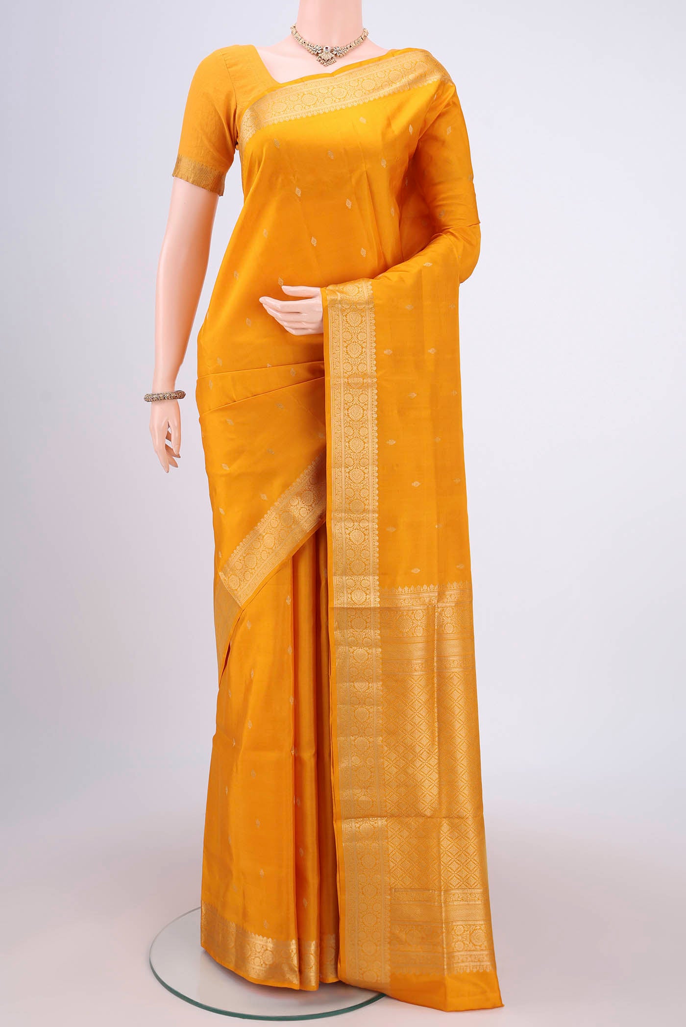 Yellow Soft Silk Saree with Zari Butta on the body and Zari Border.  displayed on a mannequin