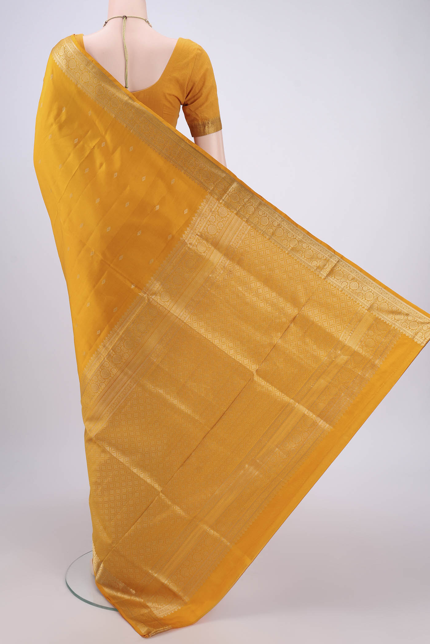 Flat view of Yellow Soft Silk Saree with Zari Butta on the body and Zari Border. 