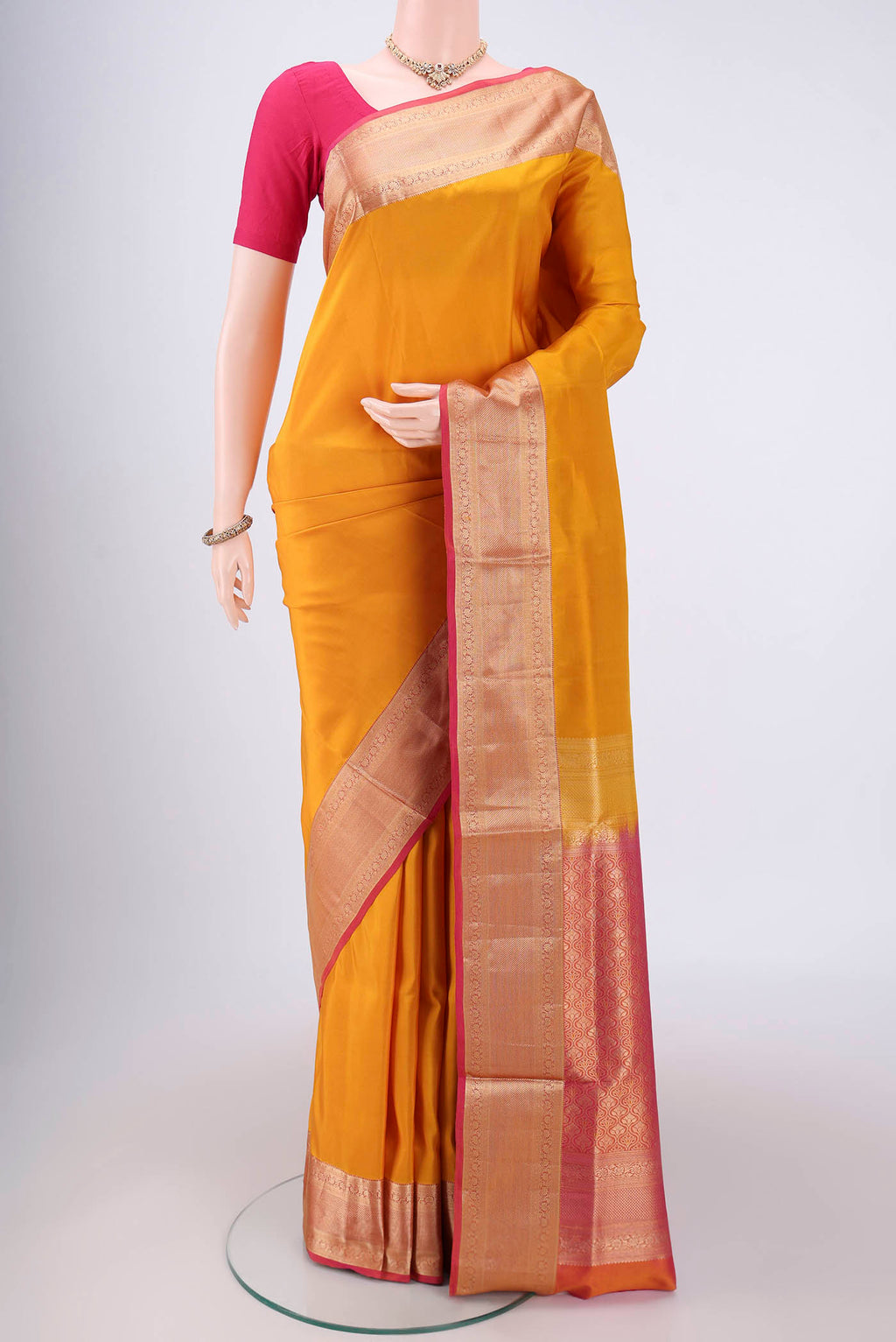 Yellow Soft Silk Saree with Zari Butta on the body and Zari Border.  displayed on a mannequin