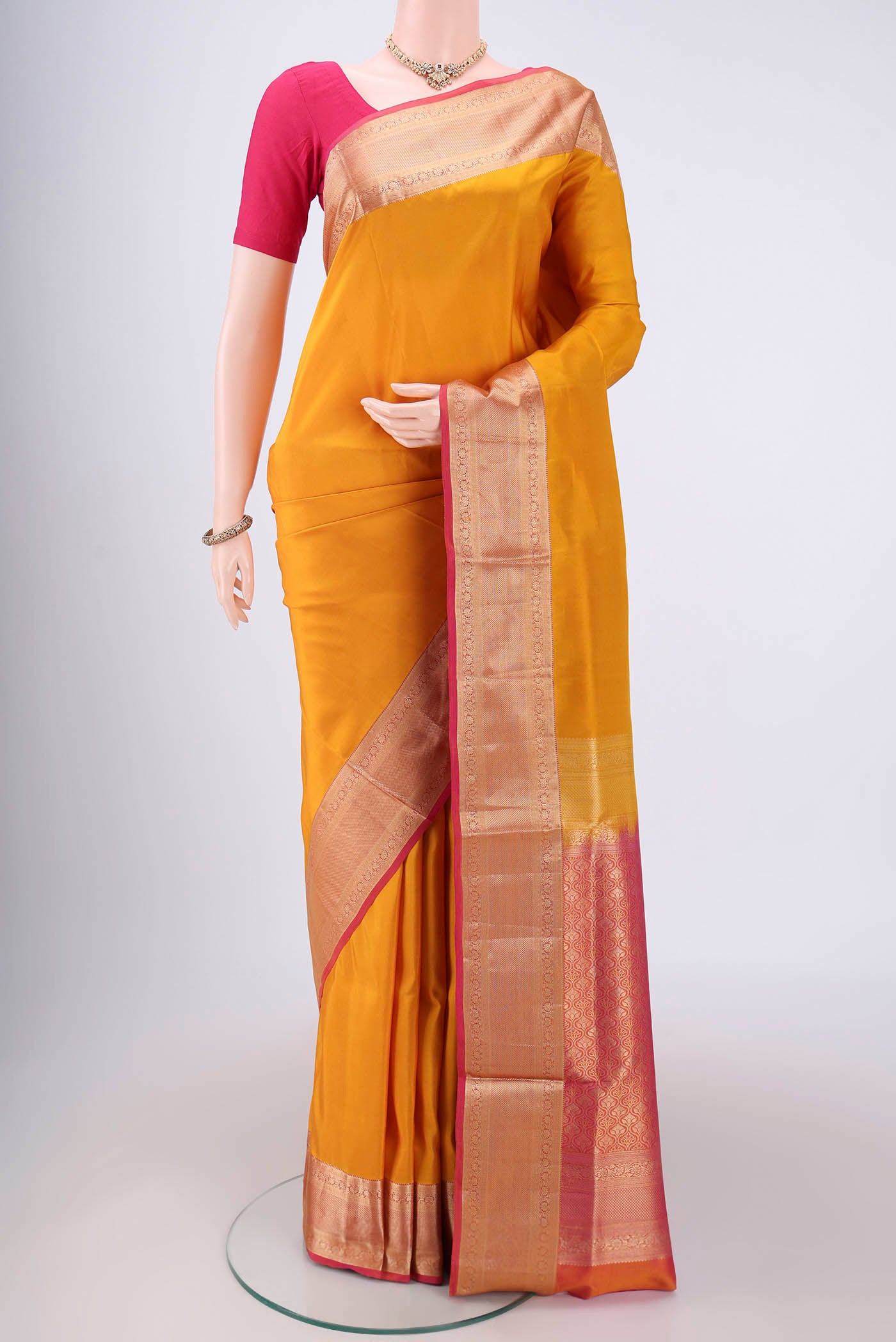 Yellow Soft Silk Saree with Zari Butta on the body and Zari Border.  displayed on a mannequin