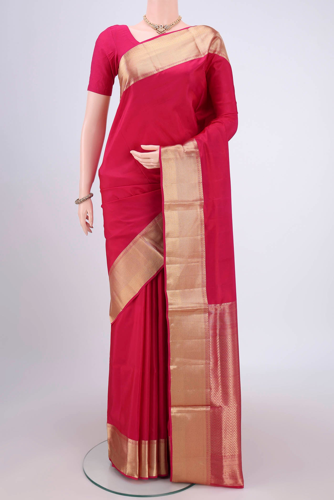 Rani Pink Soft Silk Saree with Zari Butta on the body and Zari Border.  displayed on a mannequin