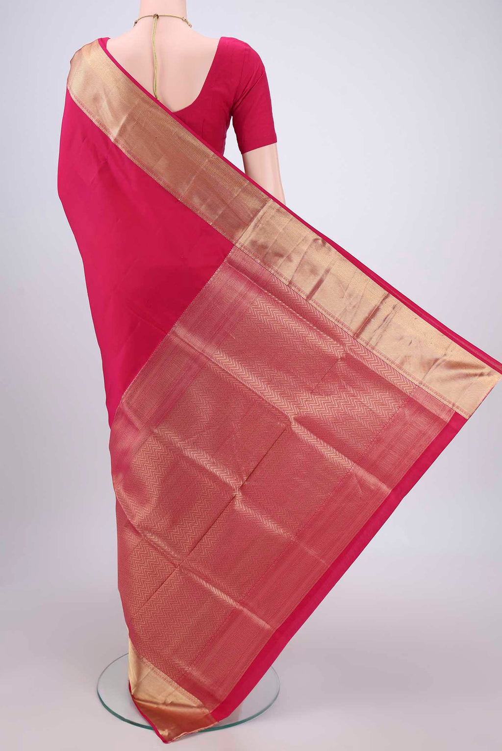 Flat view of Rani Pink Soft Silk Saree with Zari Butta on the body and Zari Border. 
