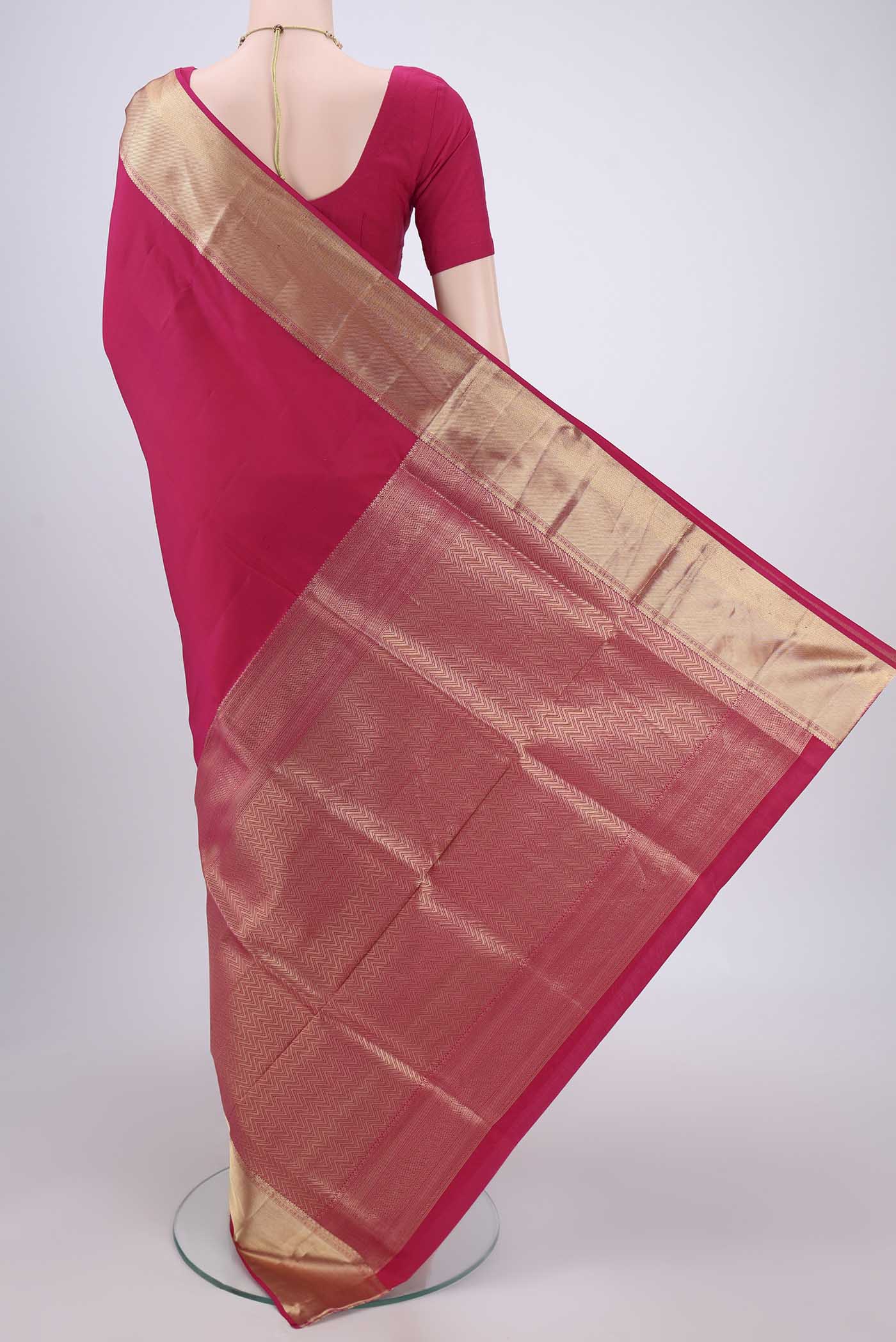 Flat view of Rani Pink Soft Silk Saree with Zari Butta on the body and Zari Border. 