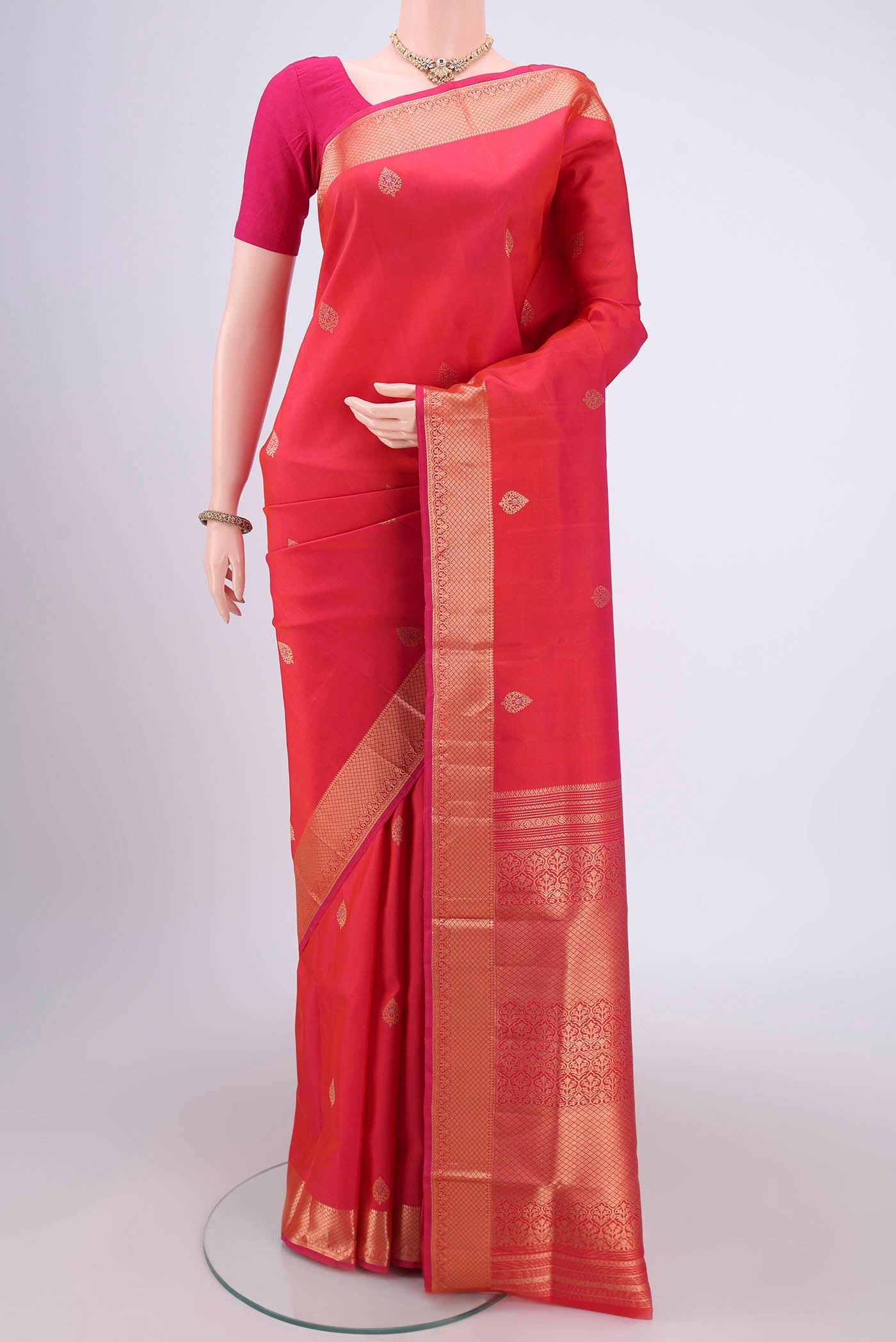 Orange Soft Silk Saree with Zari Butta on the body and Zari Border.  displayed on a mannequin