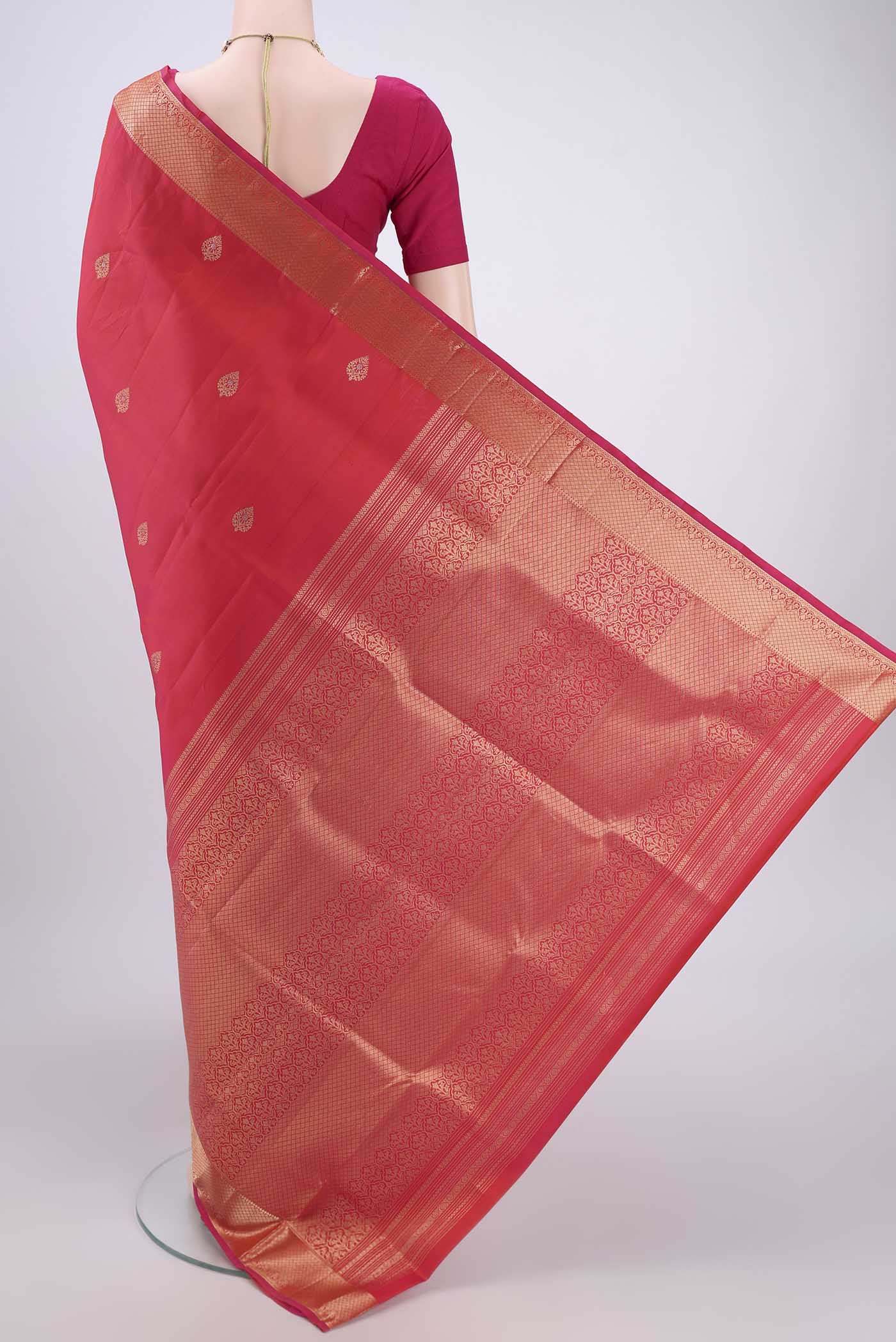 Flat view of Orange Soft Silk Saree with Zari Butta on the body and Zari Border. 