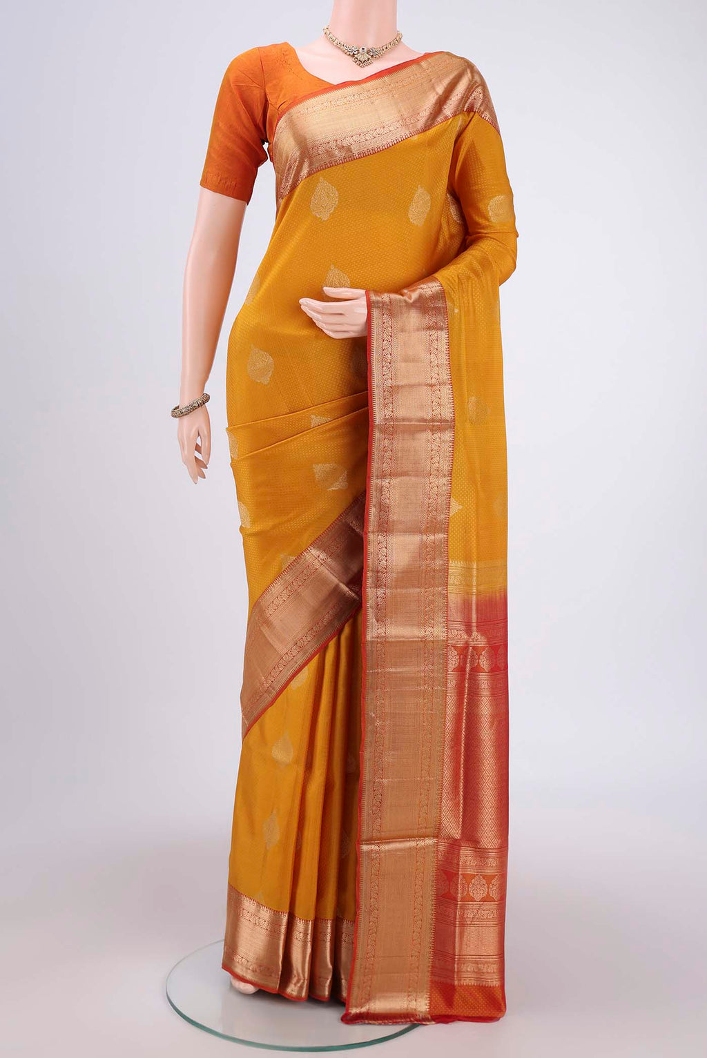 Yellow Soft Silk Saree with Zari Butta on the body and Zari Border.  displayed on a mannequin