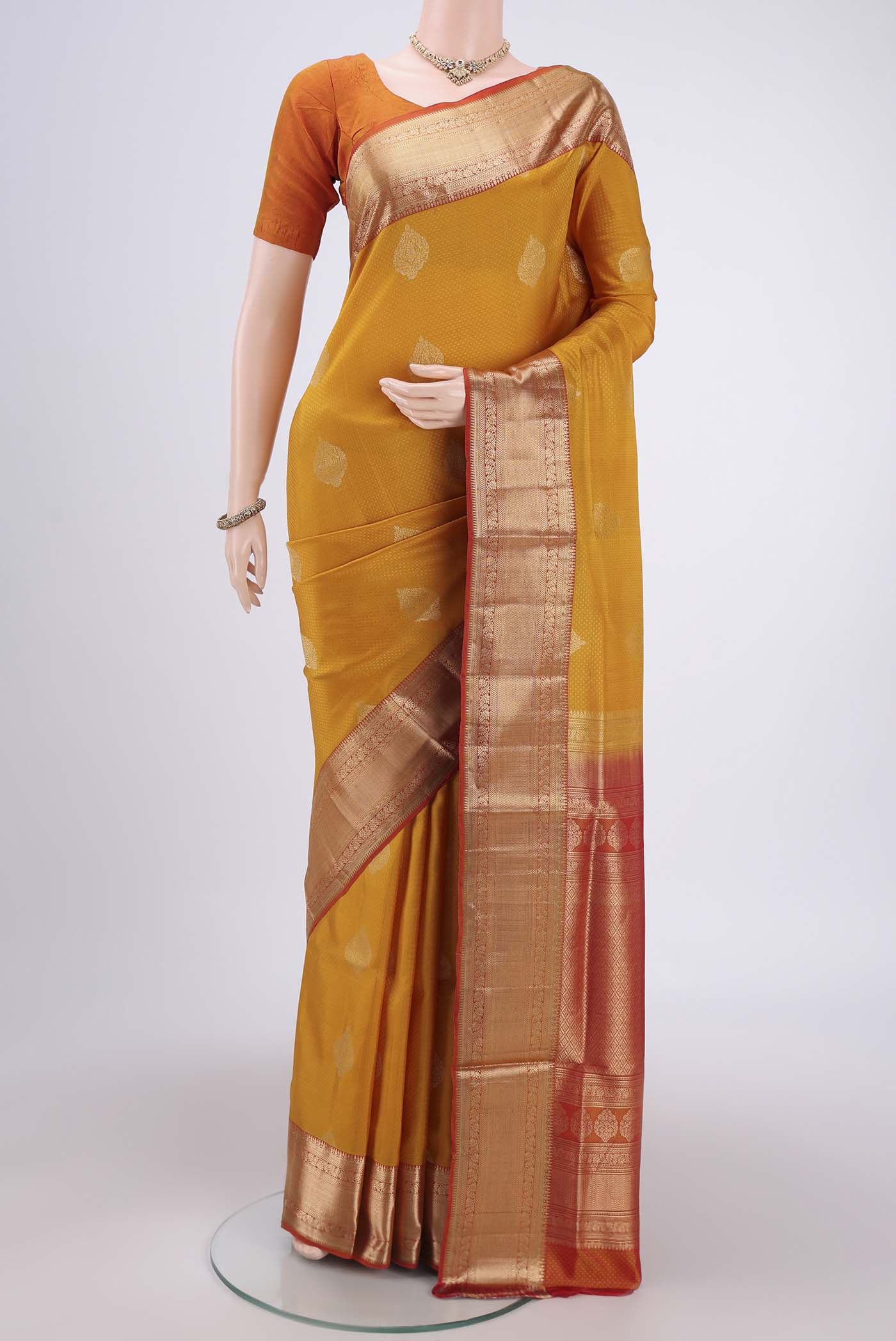 Yellow Soft Silk Saree with Zari Butta on the body and Zari Border.  displayed on a mannequin