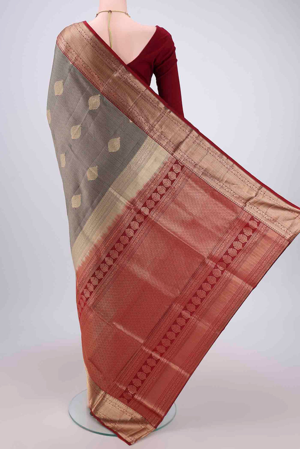 Flat view of Grey Soft Silk Saree with Zari Butta on the body and Zari Border. 