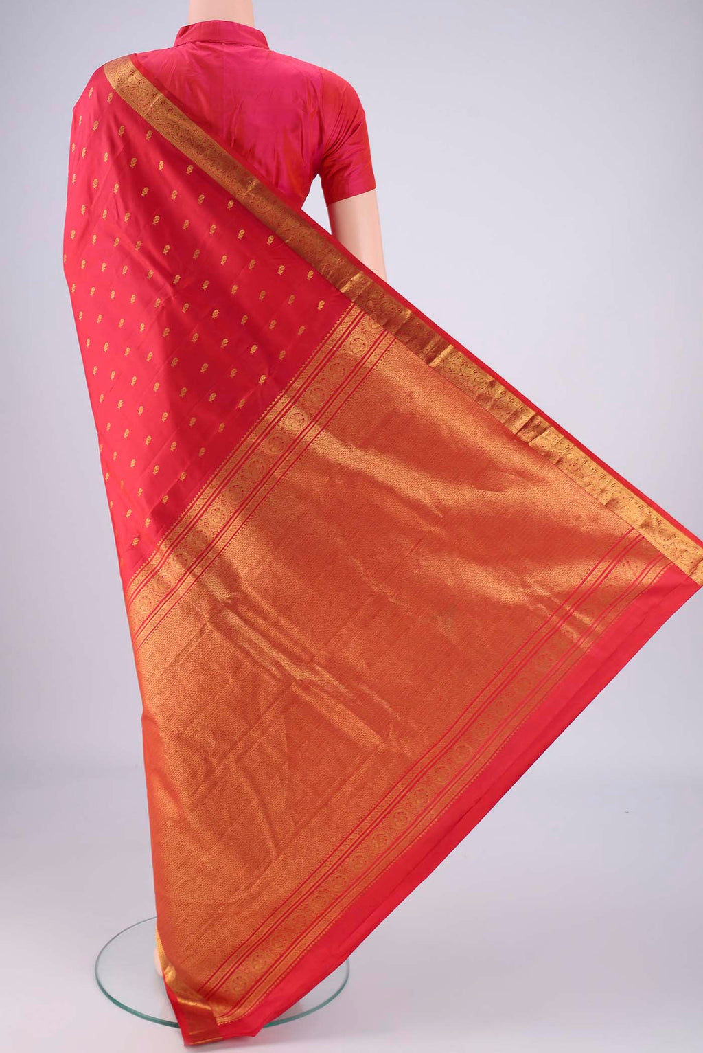 Flat view of Red Dual Tone Kanchipuram Saree with Zari Butta on the body and Zari Border. 