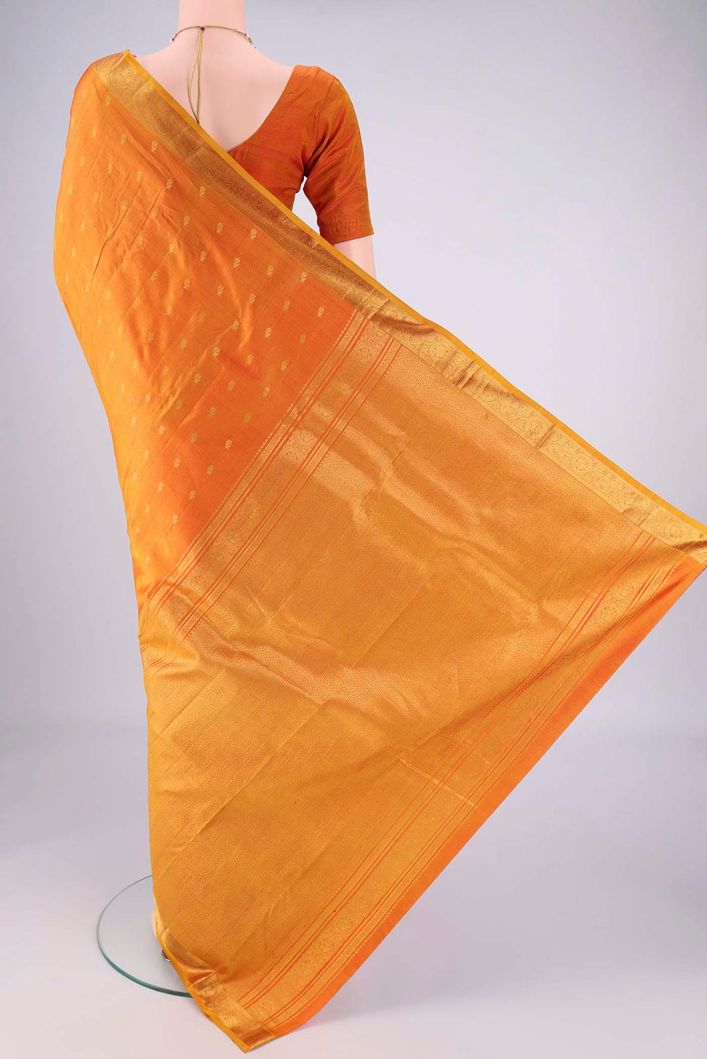 Flat view of Brick Orange Kanchipuram Silk Saree with Zari Butta on the body and Zari Border. 