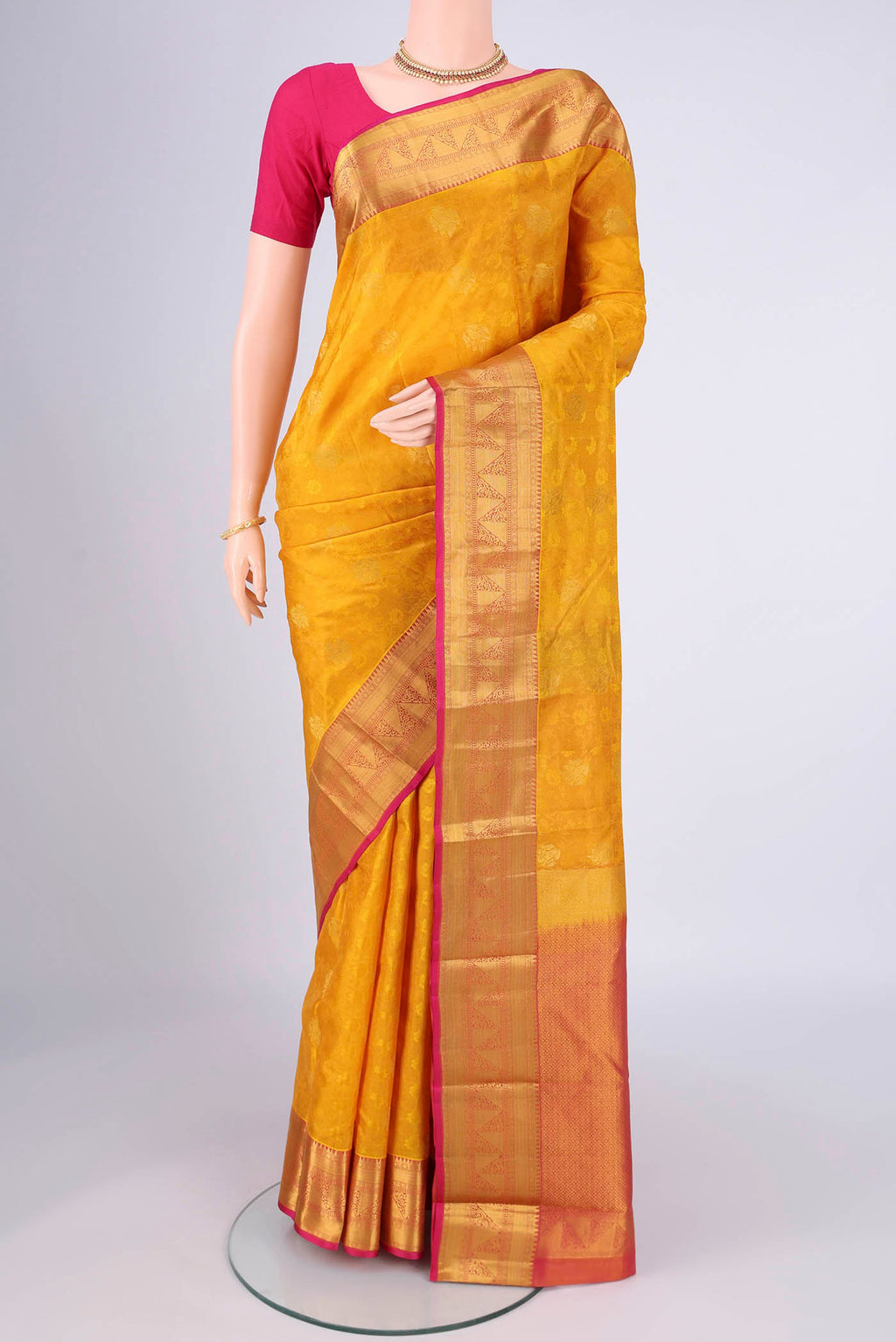 Yellow Kanchipuram Silk Saree with Jacquard design on the body and Zari Border.  displayed on a mannequin