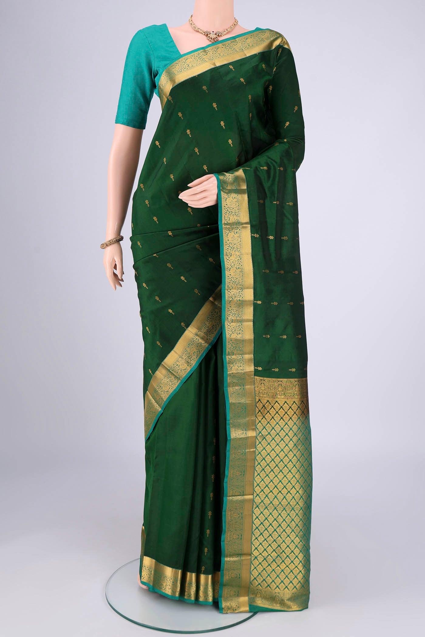 Bottle Green Nangavalli Silk [ Salem ] Saree with Zari Butta on the body and Zari Border.  displayed on a mannequin
