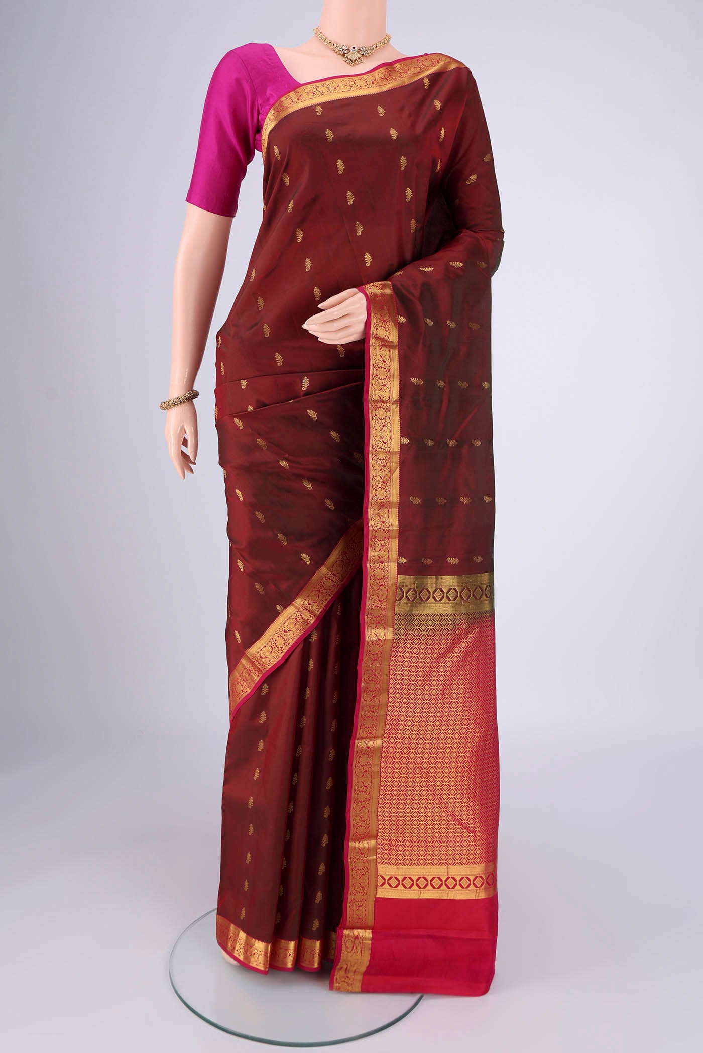 Maroon Nangavalli Silk [ Salem ] Saree with Zari Butta on the body and Zari Border.  displayed on a mannequin