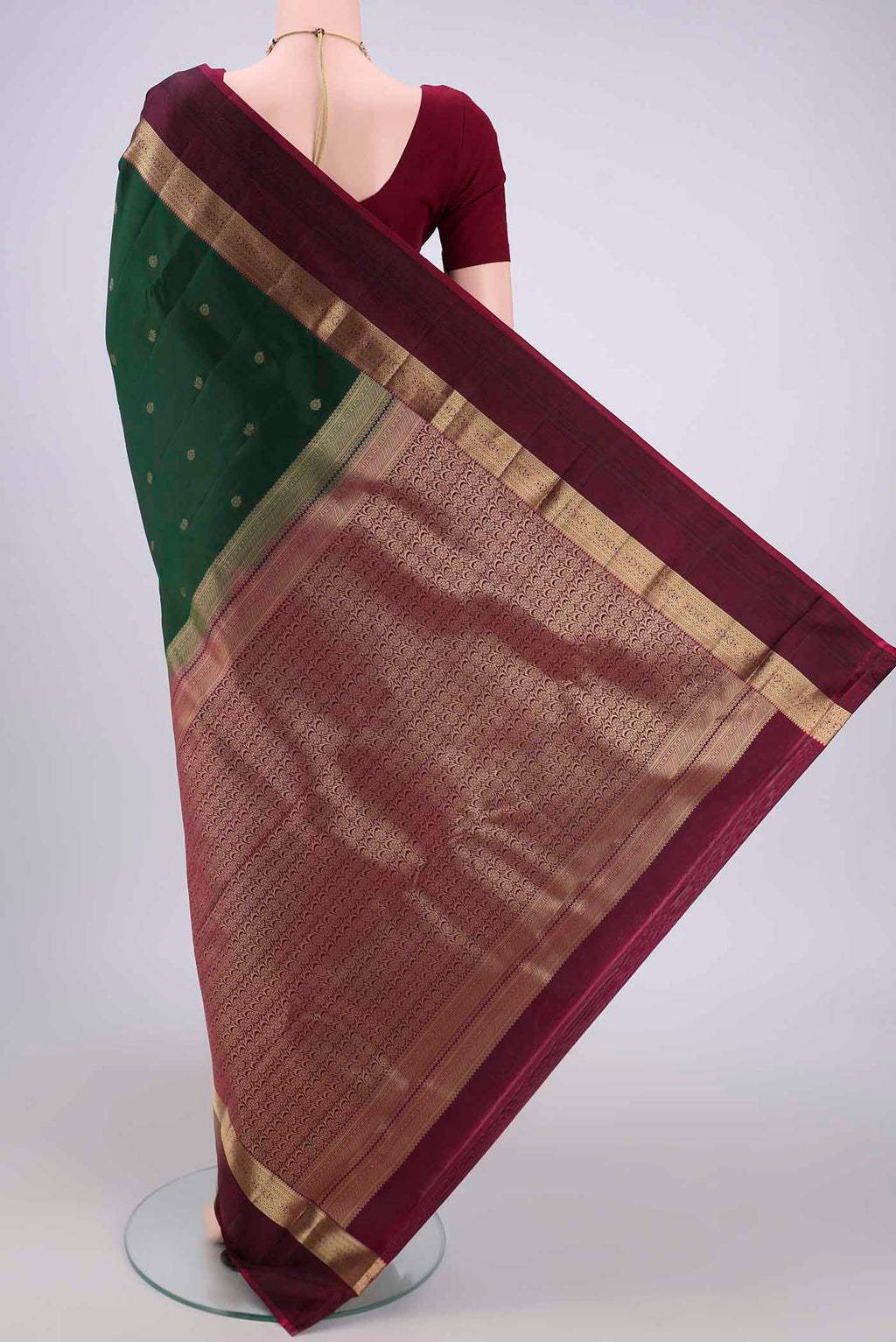 Flat view of Bottle Green Kanchipuram Silk Saree with Zari Butta on the body and Zari And Thread Border. 