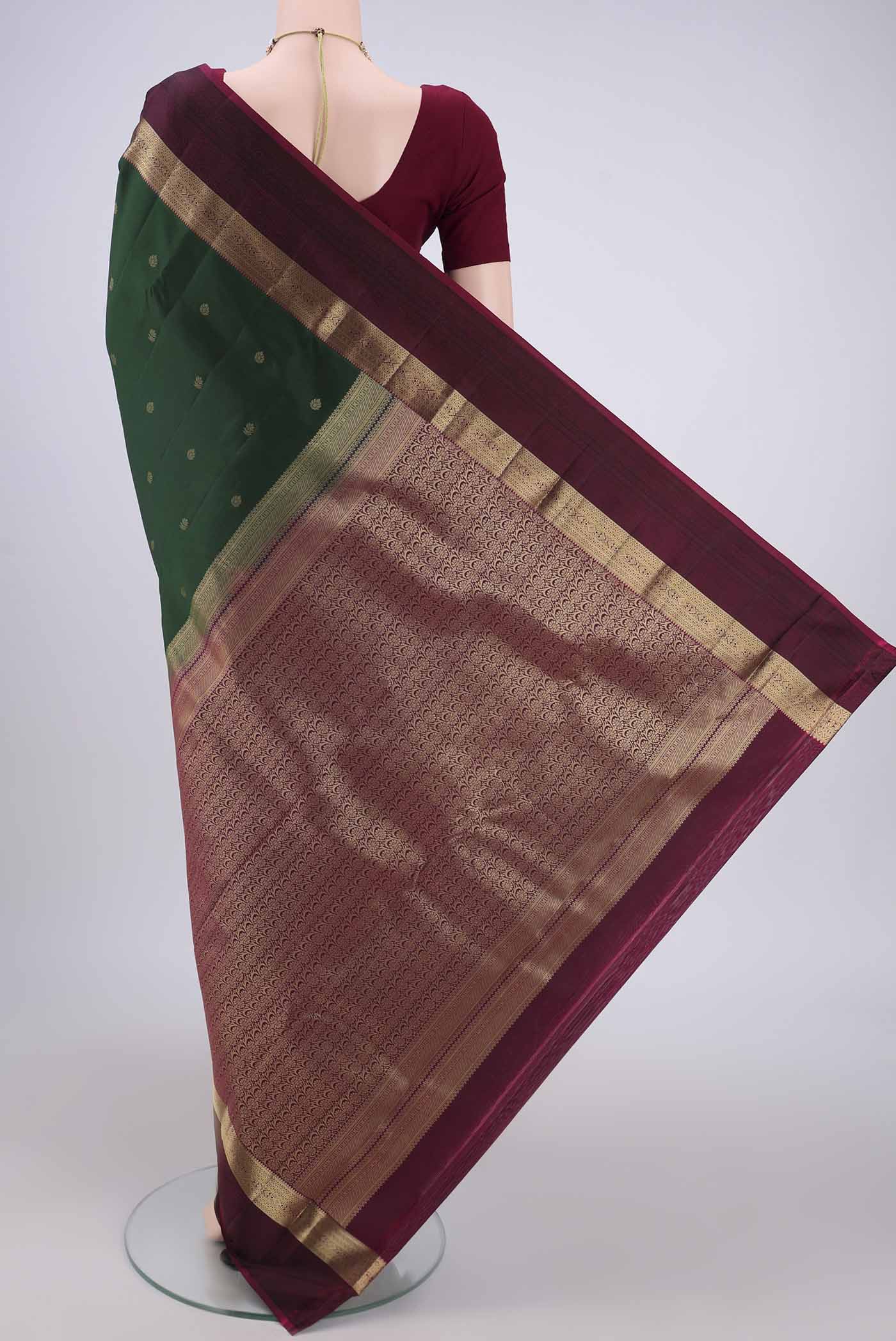 Flat view of Bottle Green Kanchipuram Silk Saree with Zari Butta on the body and Zari And Thread Border. 