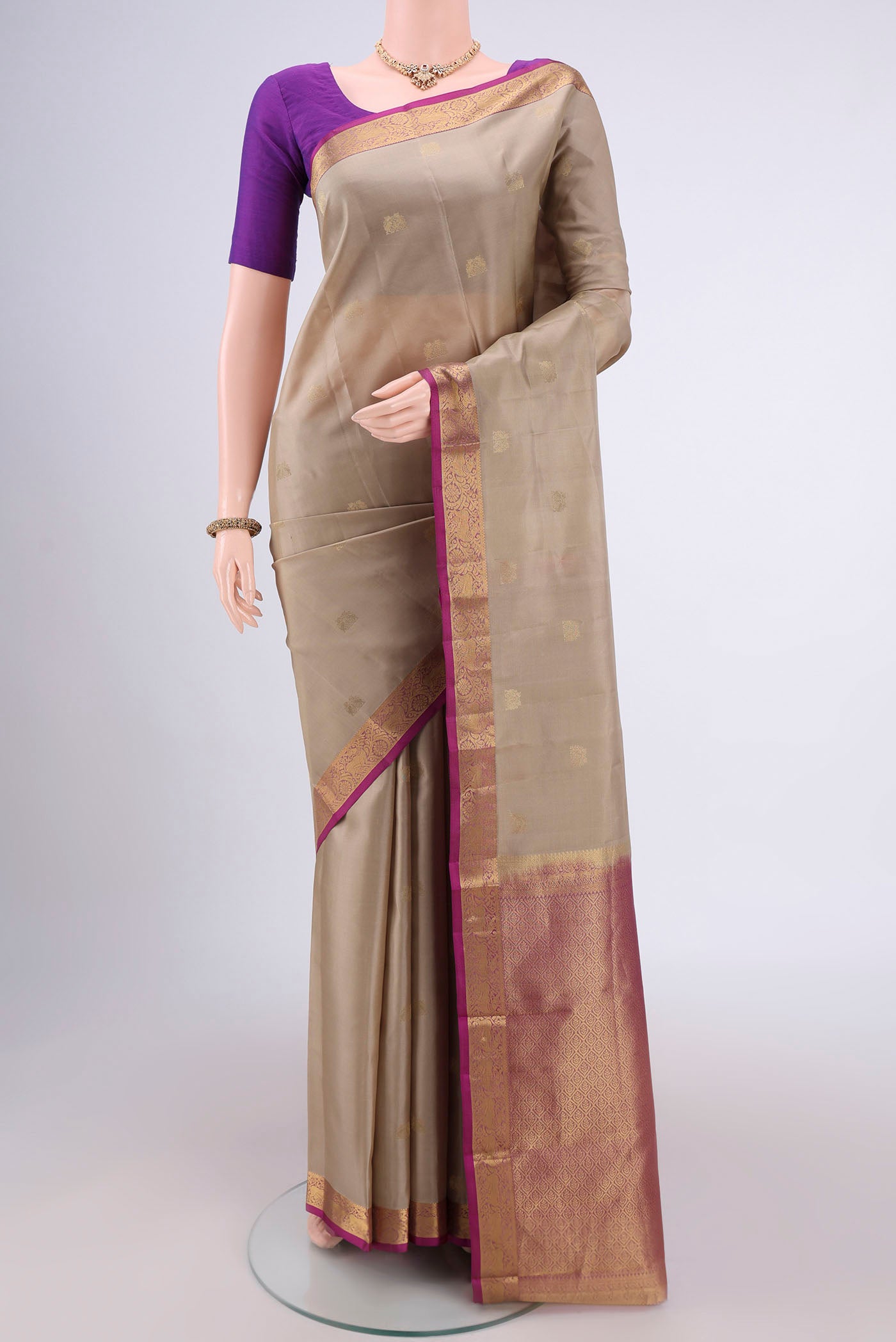 Beige Dual Tone Kanjivaram Silk Saree with Zari Butta on the body and Zari Border.  displayed on a mannequin