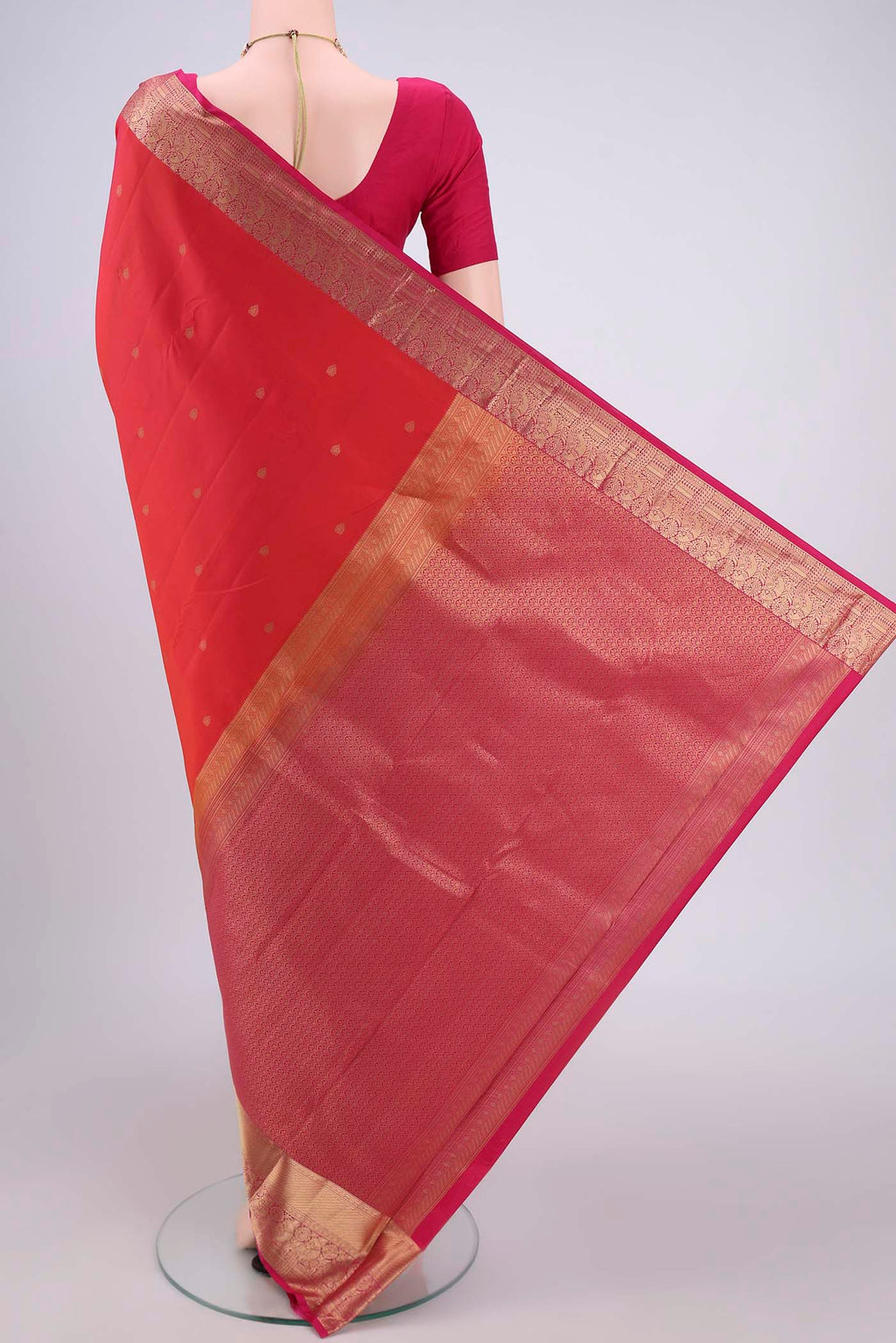 Flat view of Orange Kanchipuram Silk Saree with Zari Butta on the body and Zari Border. 
