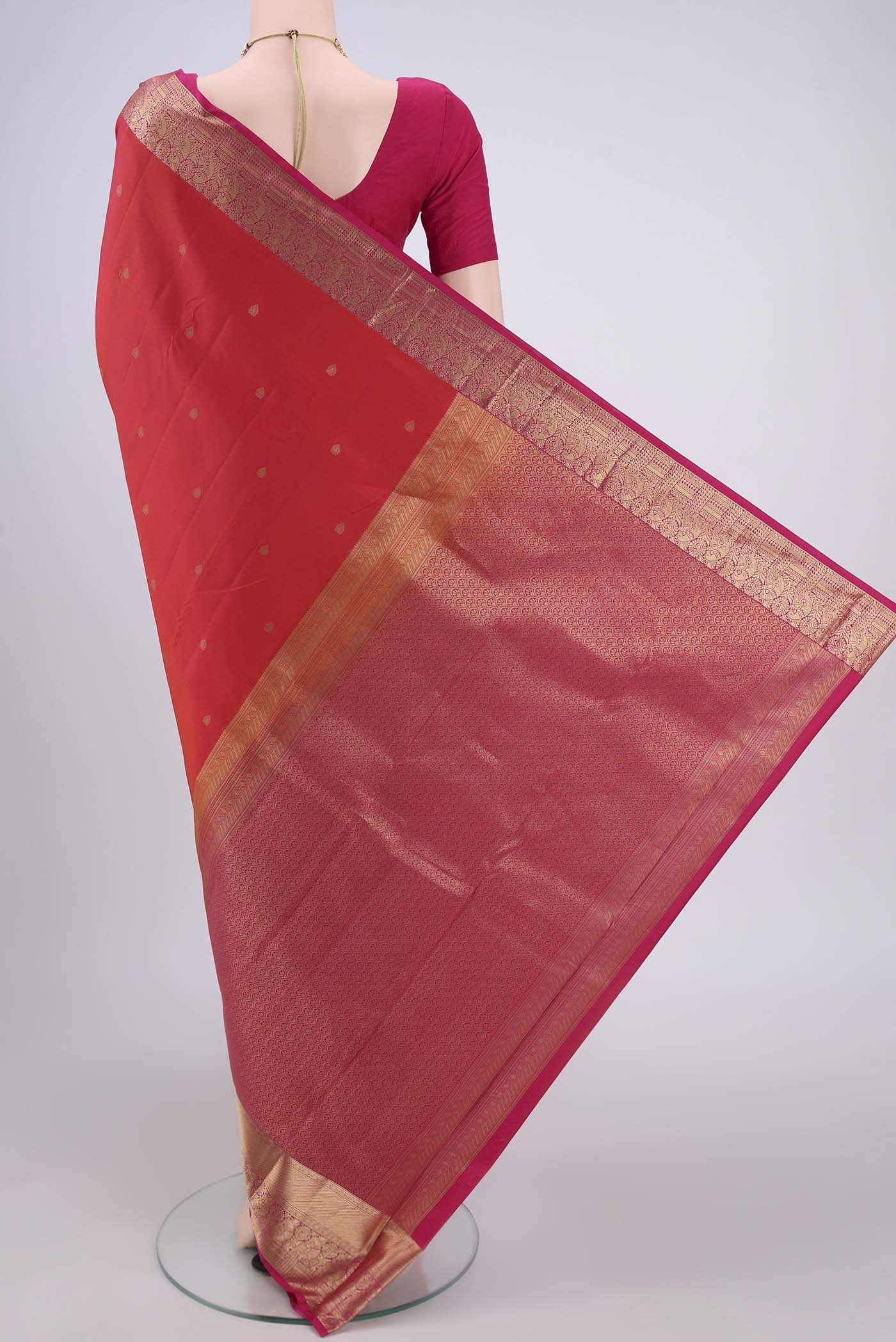 Flat view of Orange Kanchipuram Silk Saree with Zari Butta on the body and Zari Border. 