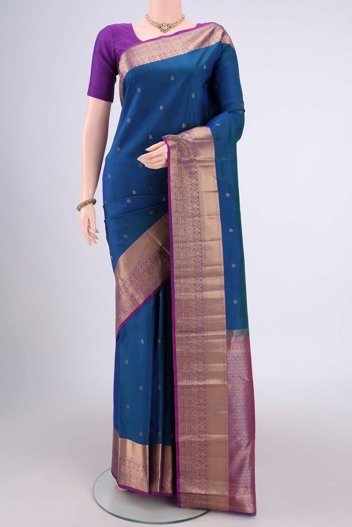 Peacock Blue Dual Tone Kanchipuram Silk Saree with Zari Butta on the body and Zari Border.  displayed on a mannequin