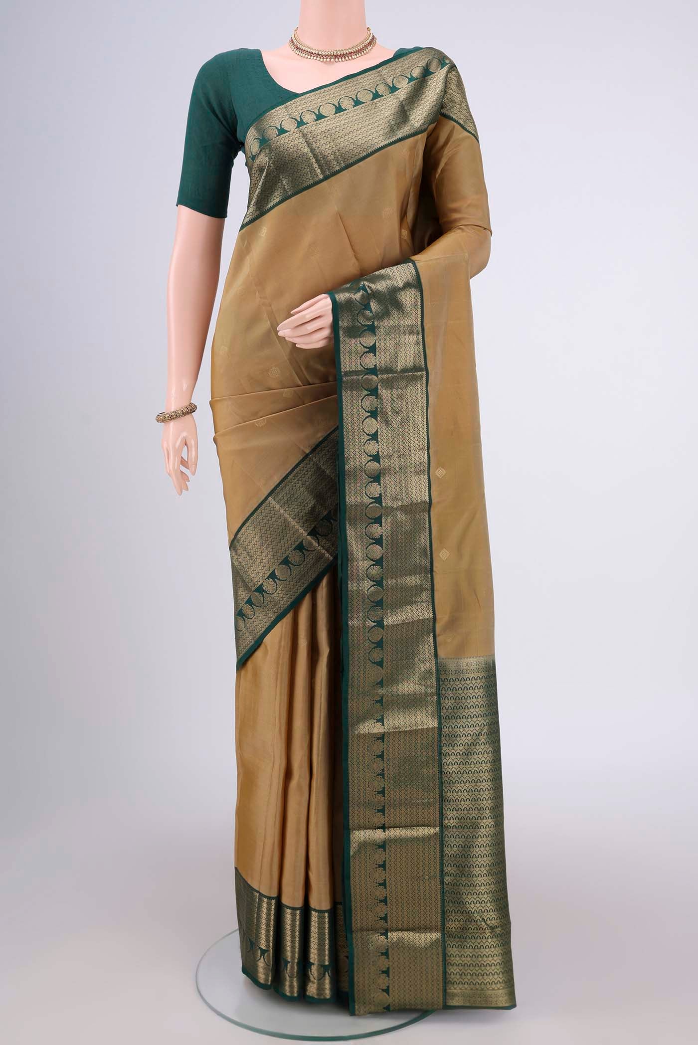 Dark Beige Kanchipuram Silk Saree with Zari Butta on the body and Zari Border.  displayed on a mannequin