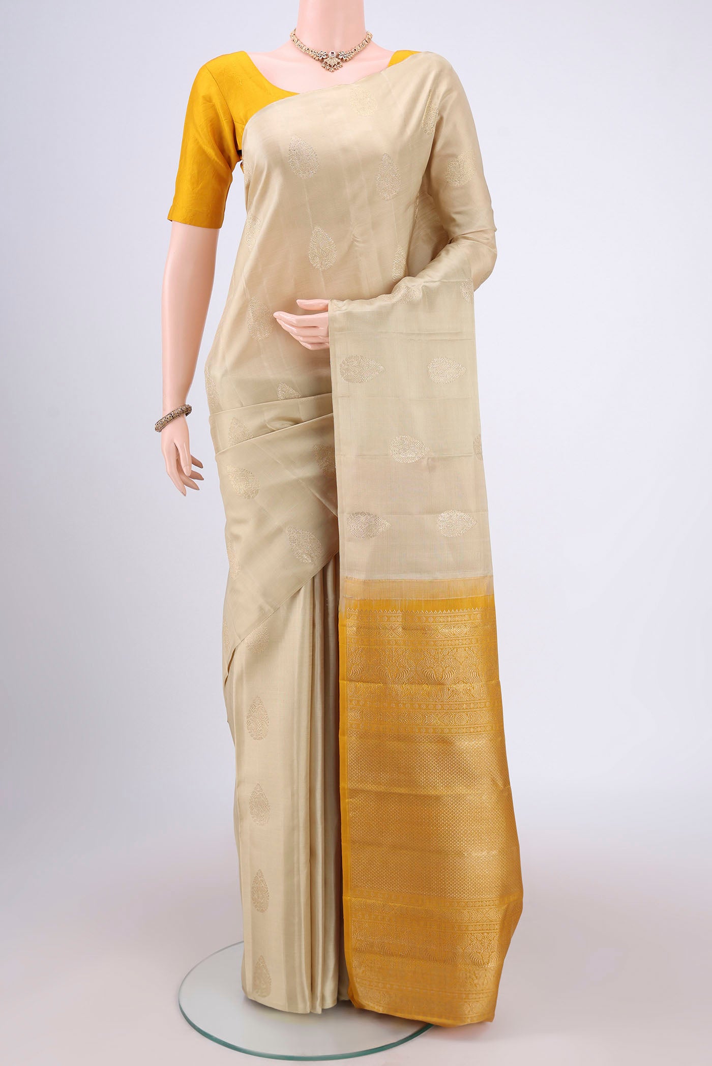 Cream Dual Tone Kanchipuram Silk Saree with Plain Body and Plain Border.  displayed on a mannequin