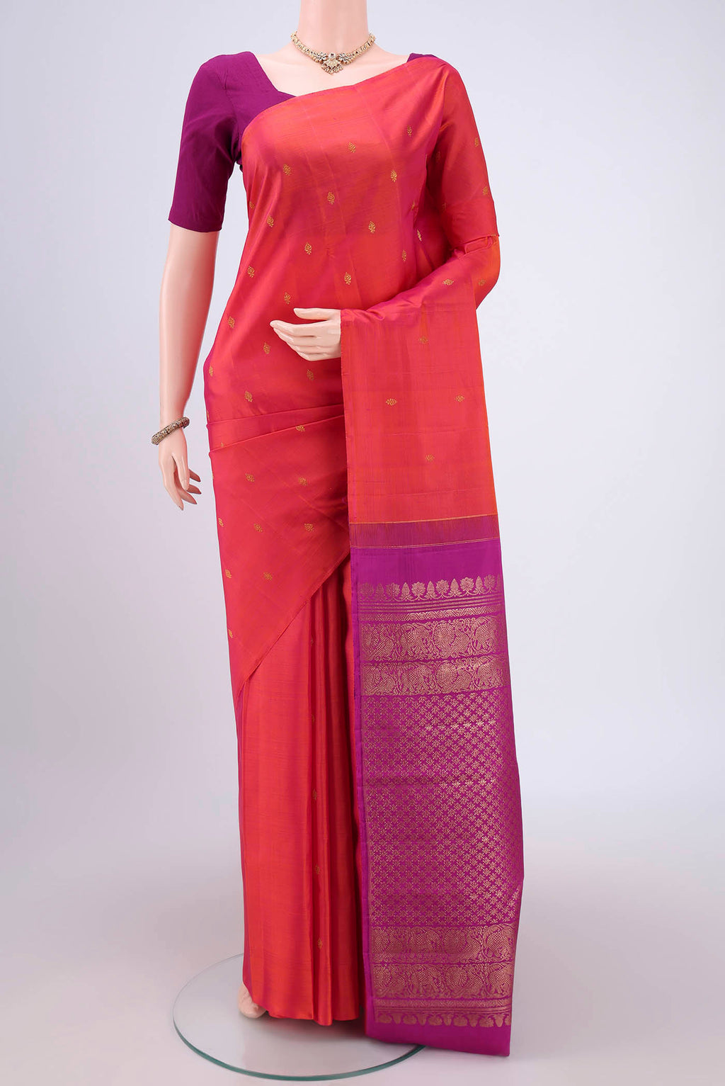Orange Dual Tone Kanchipuram Silk Saree with Zari Butta on the body and Attached Border.  displayed on a mannequin