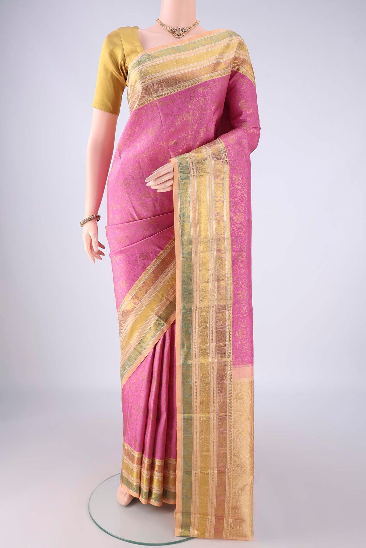 Rose pink Kanchipuram Silk Saree with Zari Brocade on the body and Zari Border.  displayed on a mannequin