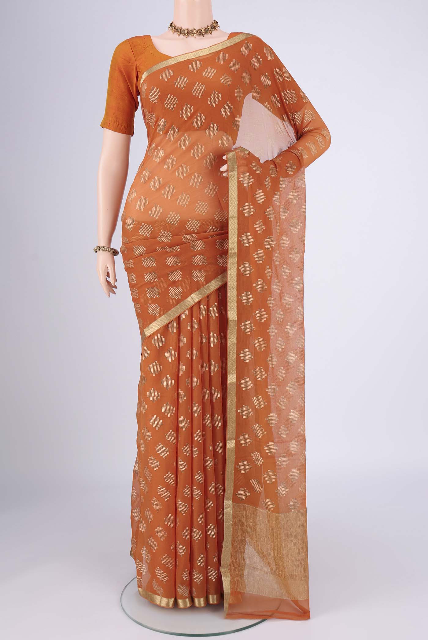 Brick Orange Mysore Chiffon Saree with Zari Butta on the body and Zari Border.  displayed on a mannequin