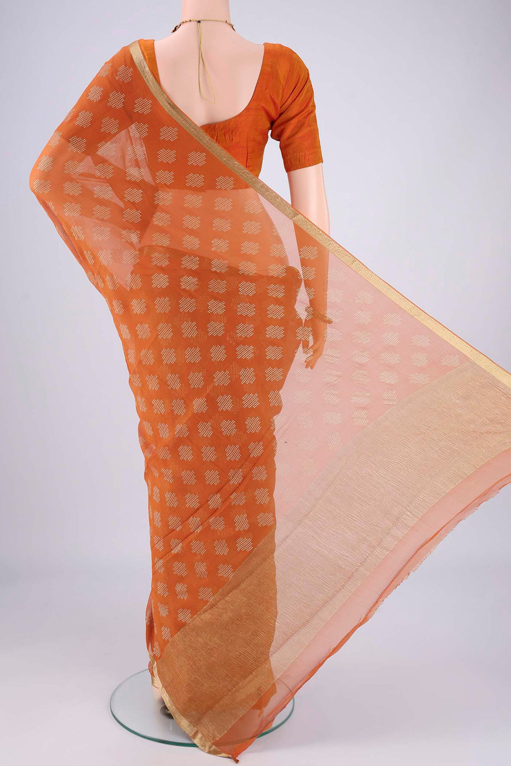 Flat view of Brick Orange Mysore Chiffon Saree with Zari Butta on the body and Zari Border. 