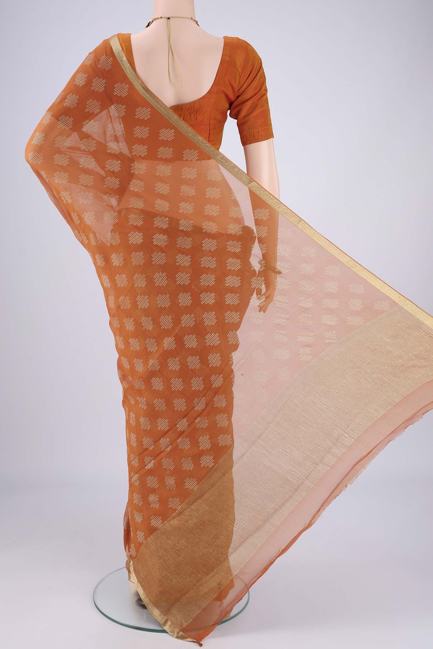 Flat view of Brick Orange Mysore Chiffon Saree with Zari Butta on the body and Zari Border. 