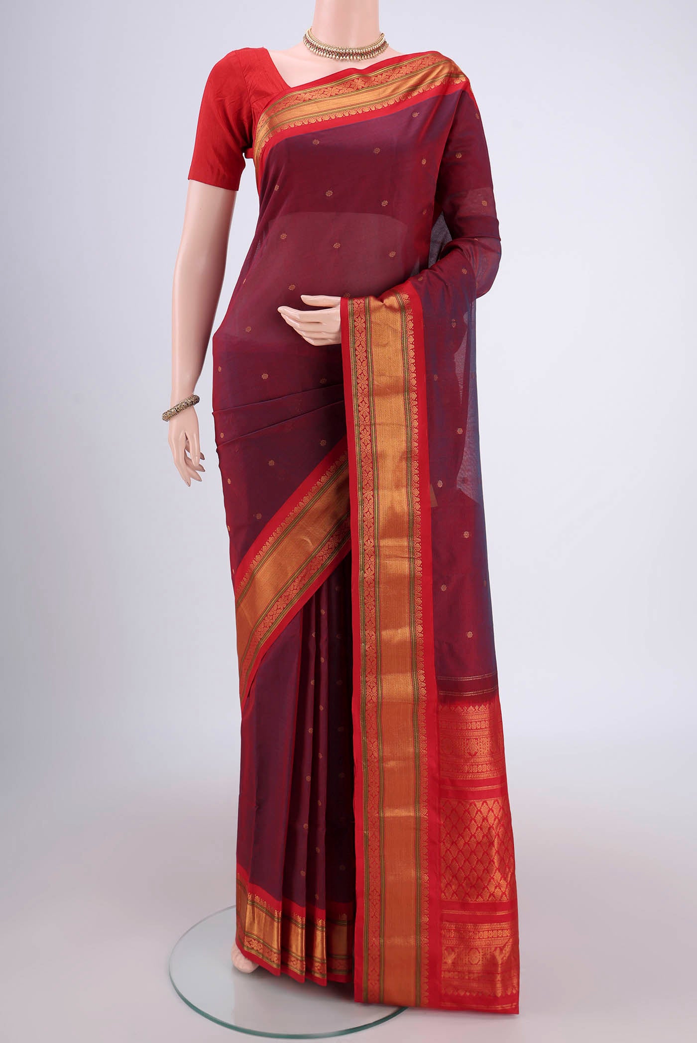 Maroon Gadwal Silk Saree with Zari Butta on the body and Zari Border.  displayed on a mannequin