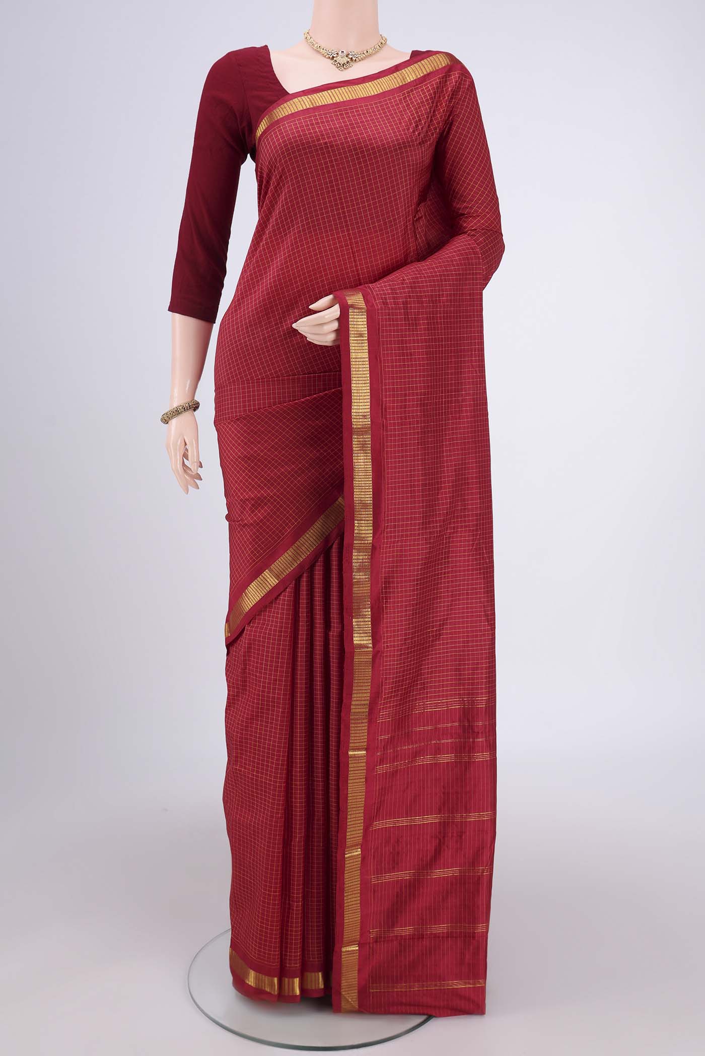 Maroon Dual Tone Kanchipuram Silk Saree with Checked design on the body and Zari Border.  displayed on a mannequin