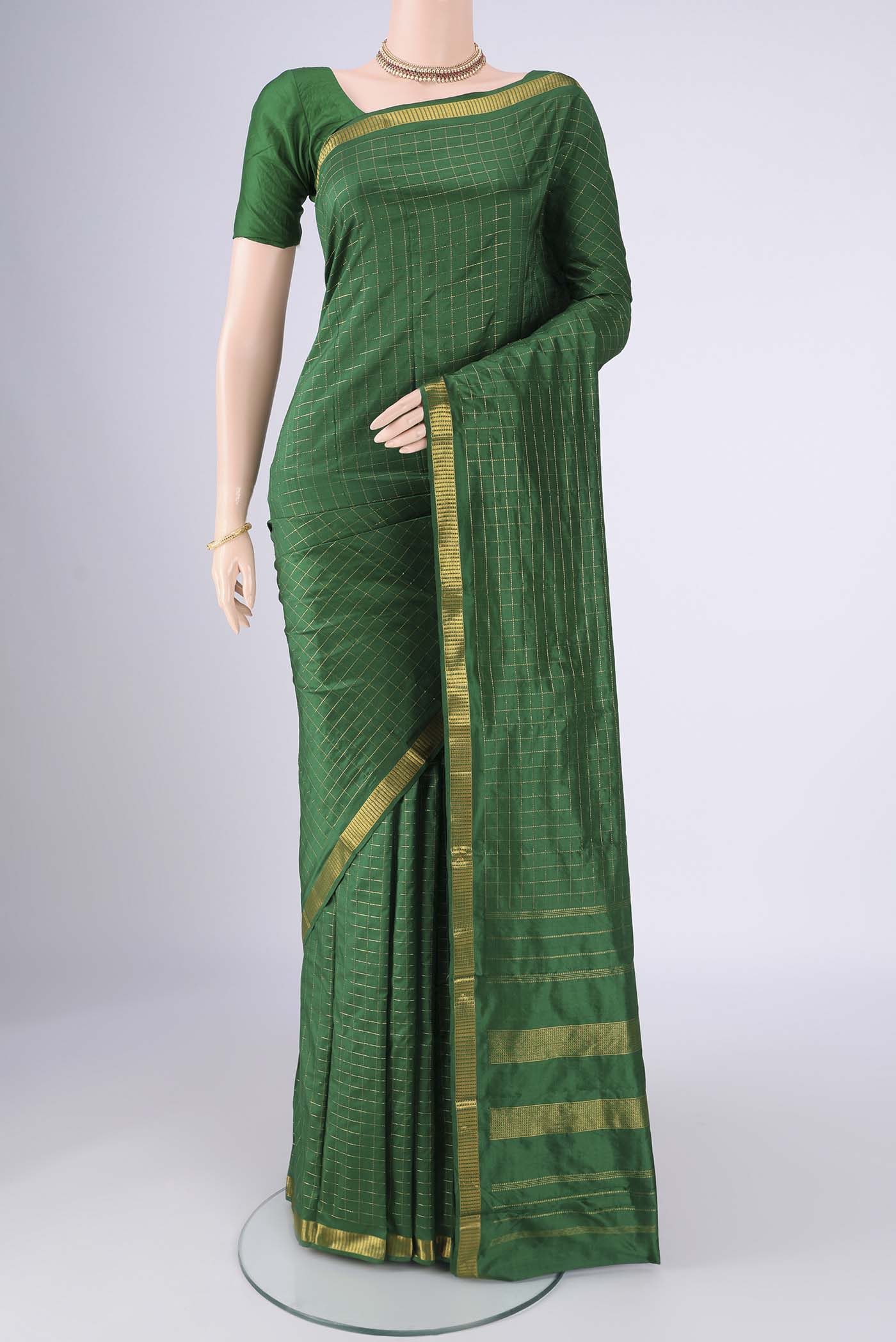 Bottle Green Kanjivaram Silk Saree with Checked design on the body and Zari Border.  displayed on a mannequin