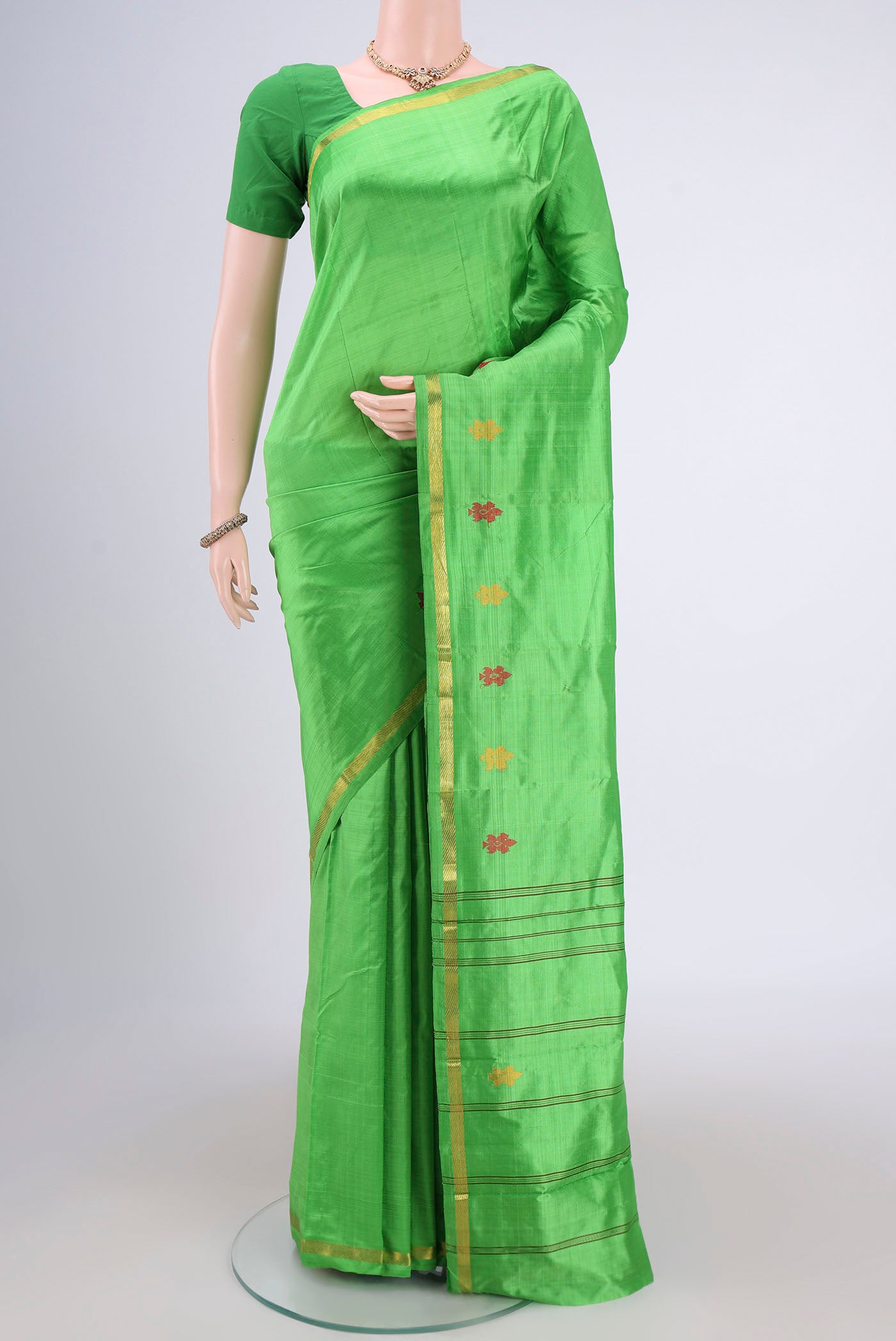 Parrot Green Kanchipuram Silk Saree with Plain Body and Zari And Thread Border.  displayed on a mannequin