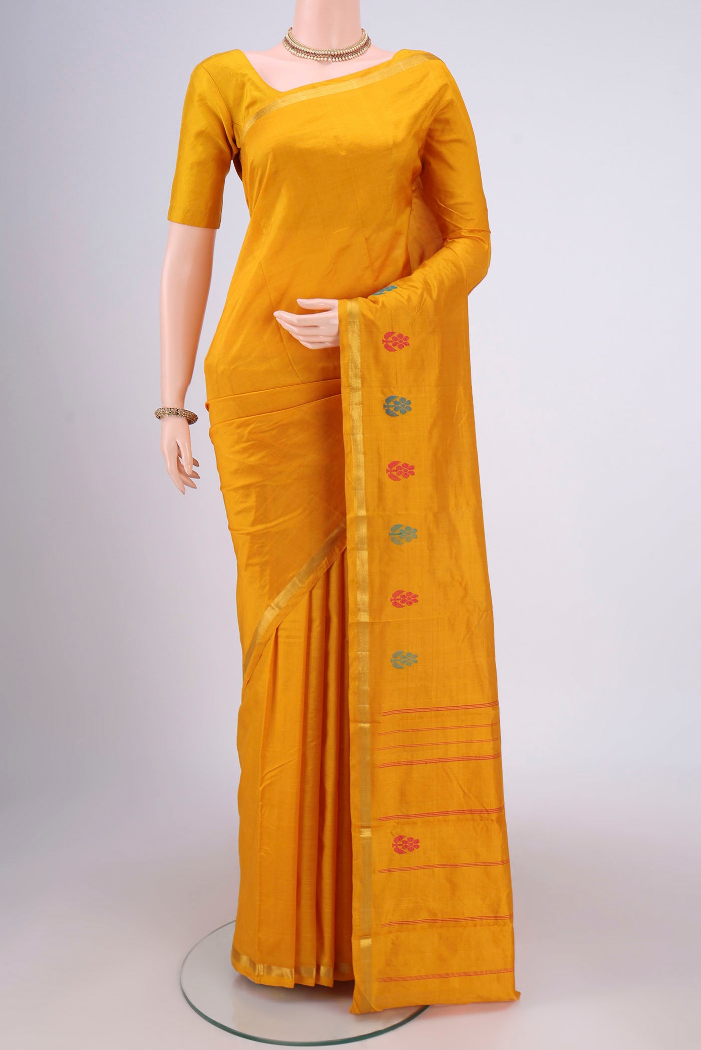 Mustard Kanchipuram Silk Saree with Plain Body and Zari And Thread Border.  displayed on a mannequin