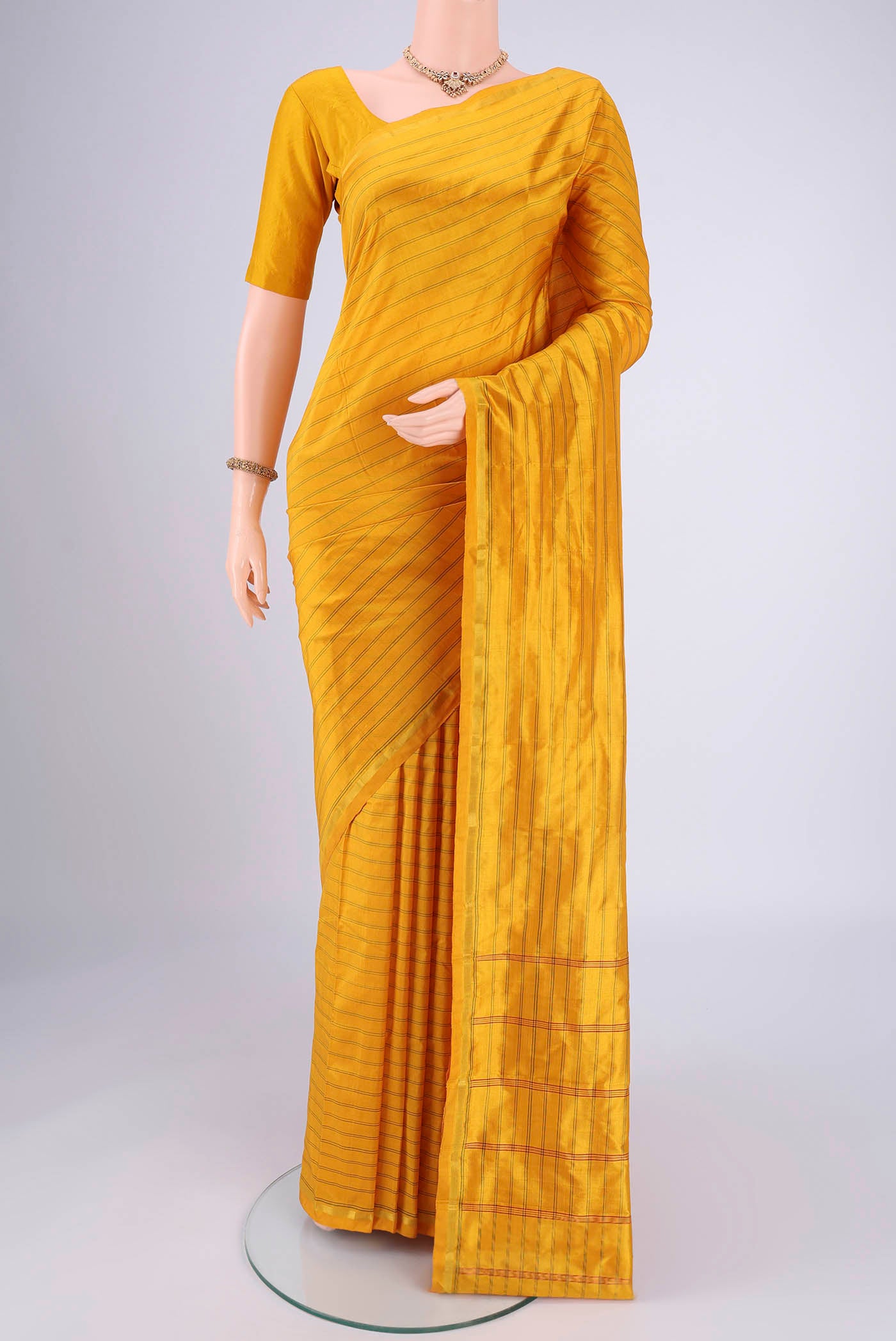 Mustard Dual Tone Kanchipuram Silk Saree with Stripes on the body and Zari Border.  displayed on a mannequin