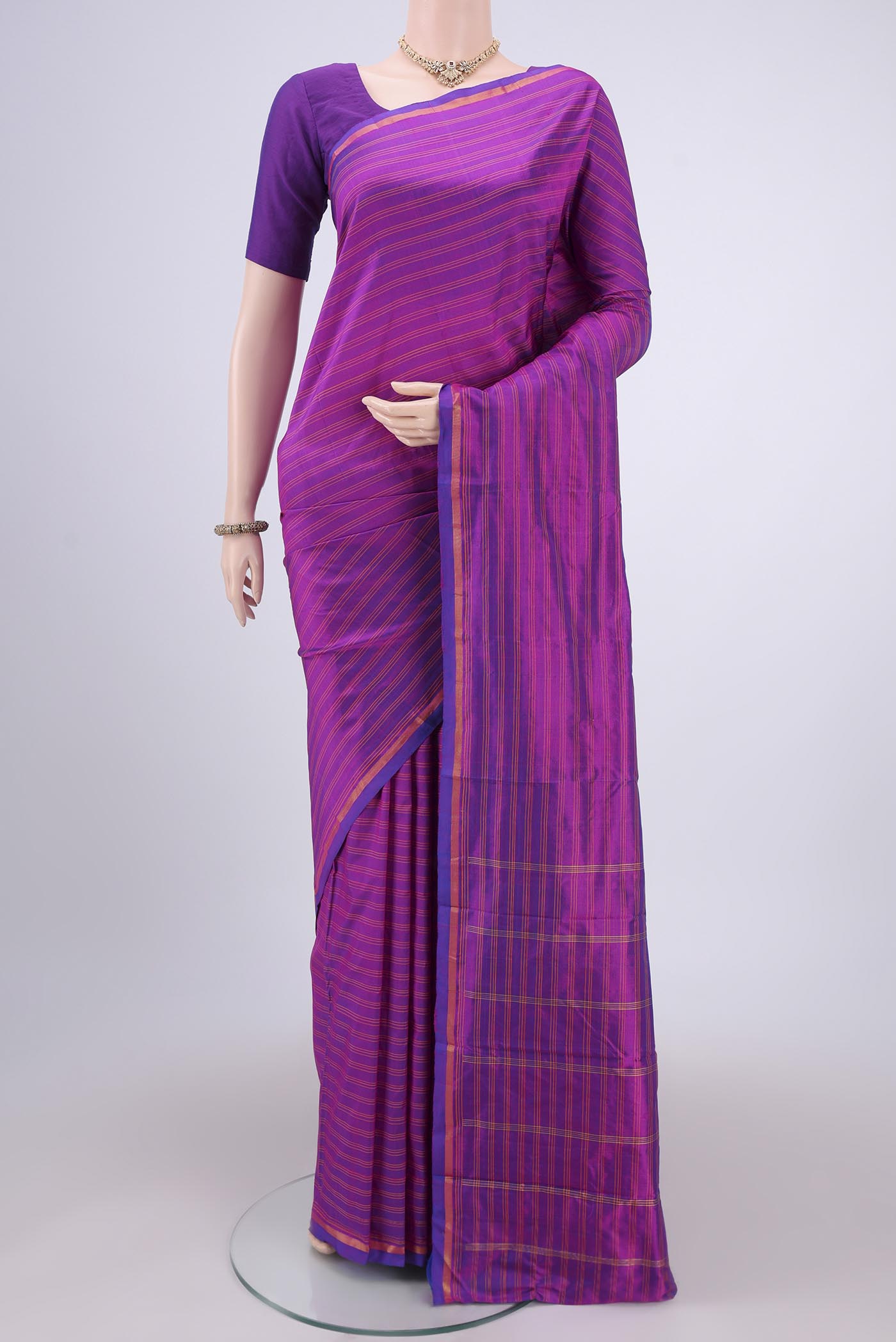 Magenta Kanchipuram Silk Saree with Stripes on the body and Zari Border.  displayed on a mannequin