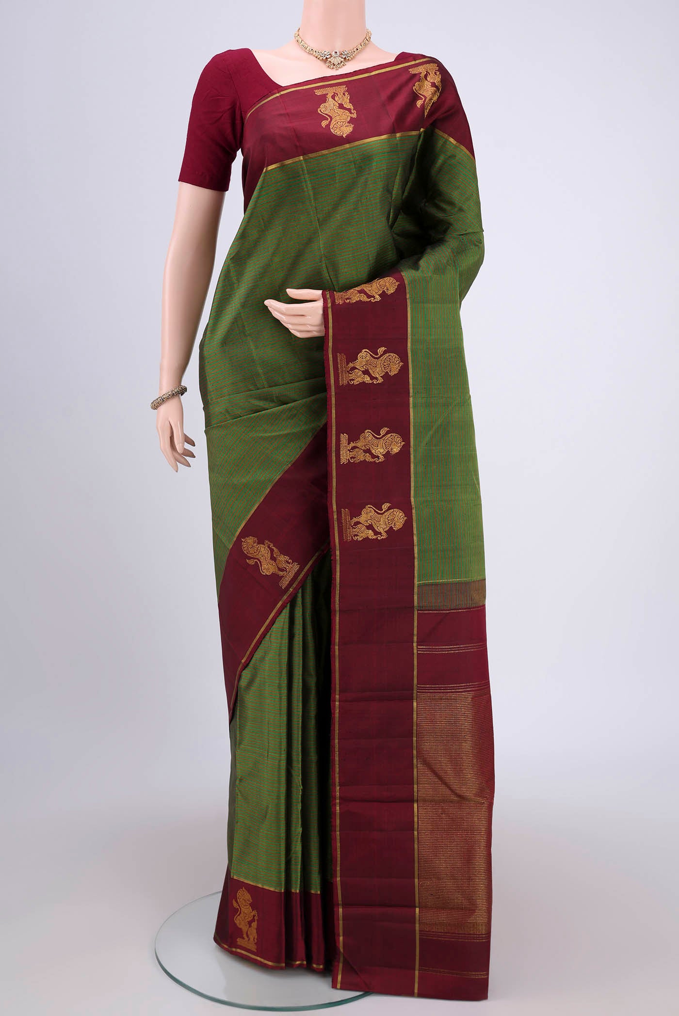 Green Kanchipuram Silk Saree with Stripes on the body and Attached Border.  displayed on a mannequin